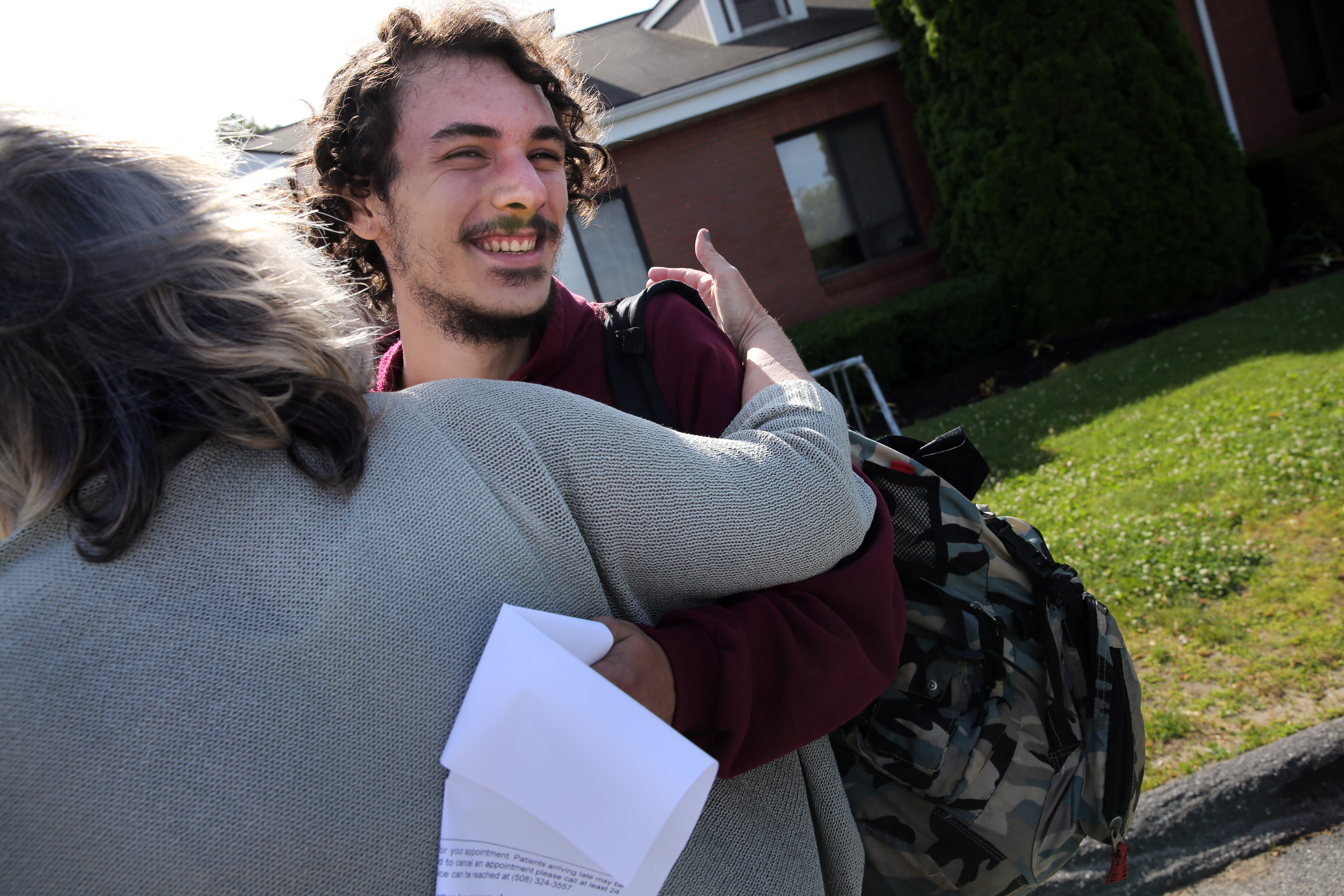 Adam Carreira, 22, of New Bedford (center) got a hug from OTC Clinician Kathy Belanger outside the Open Access Clinic at SSTAR, a treatment facility in Fall River.