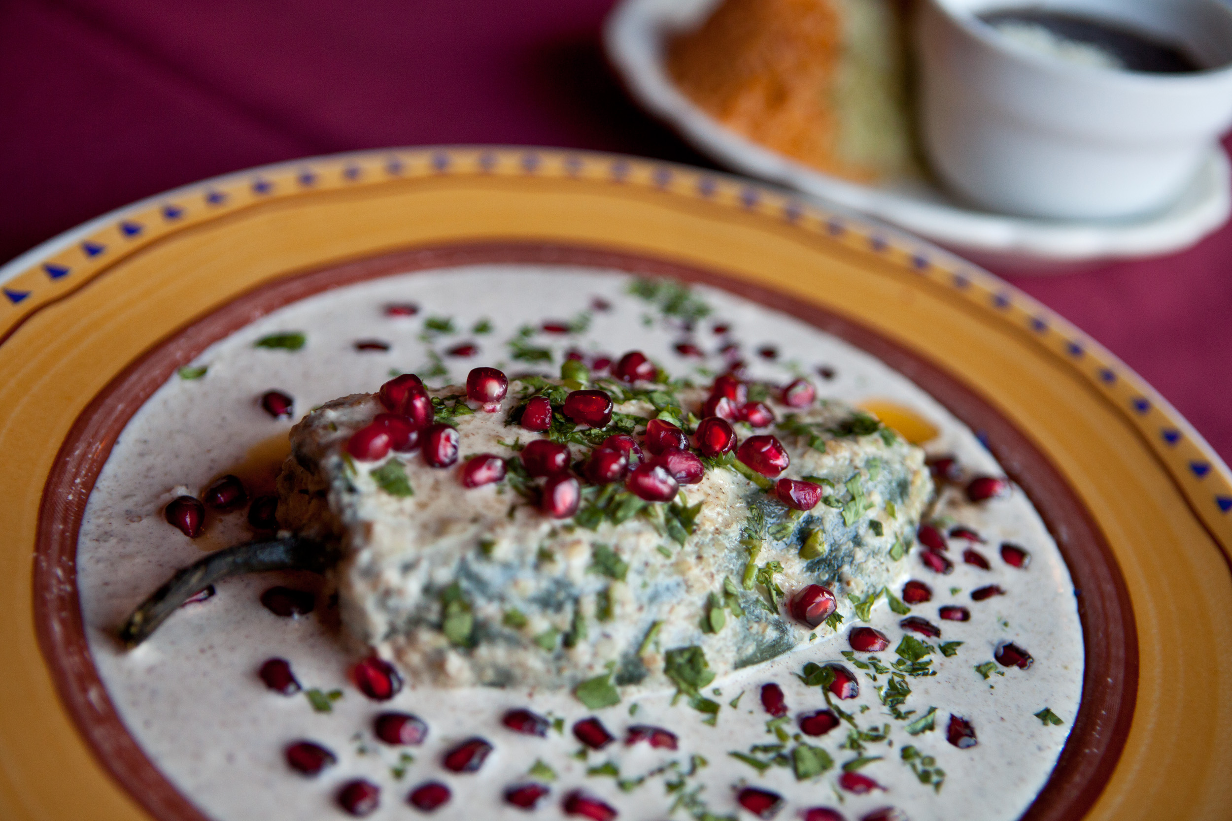 The chili relleno en nogada dish (poblano pepper stuffed with ground beef, almonds, raisins, apples, pineapples, and peaches; covered in a walnut and cinnamon sauce, topped with pomegranate seeds and cilantro) at Tu Y Yo in Somerville.