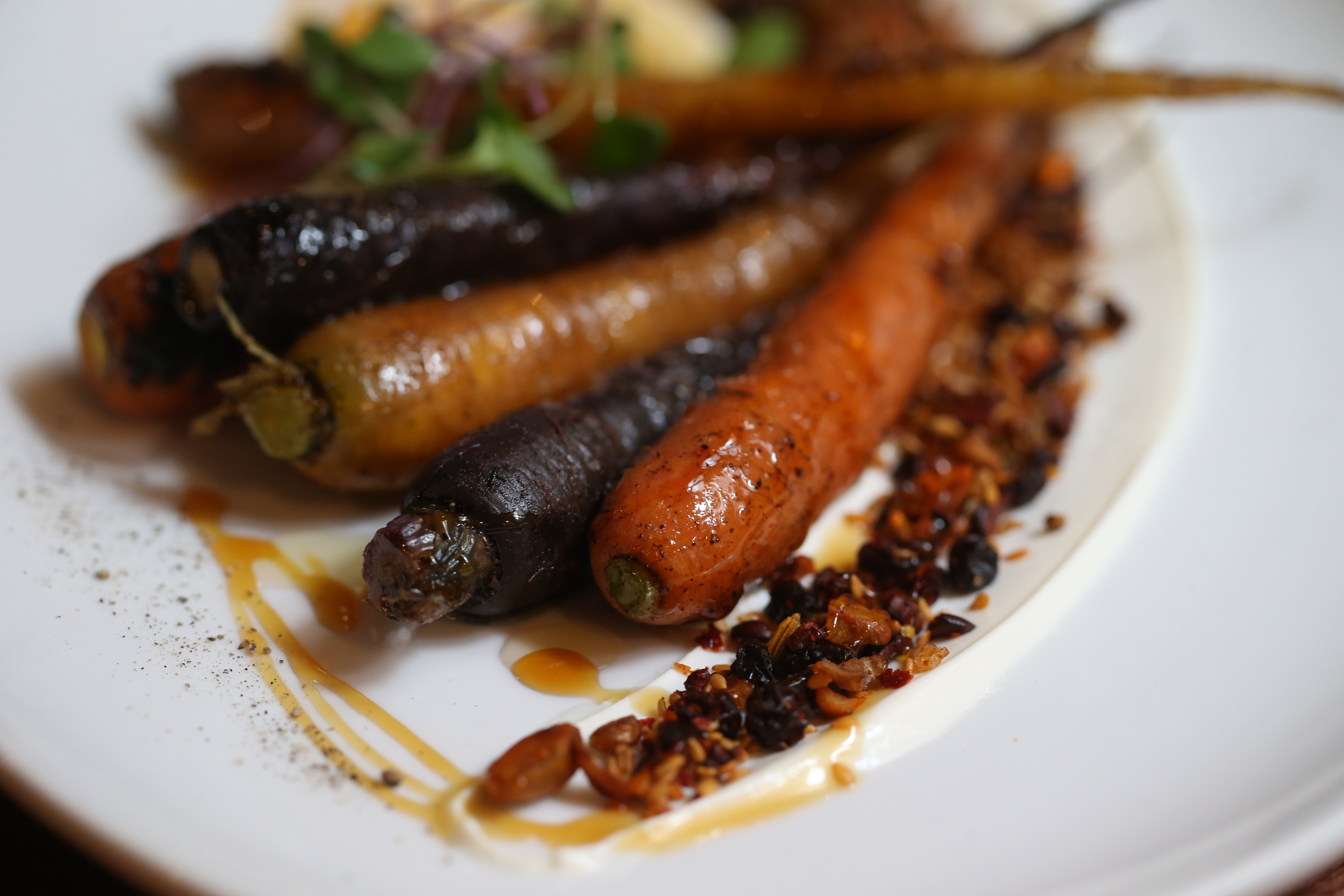 Whole grilled carrots are served with yogurt, honey, and a mixture of pistachios and other seeds at Alden & Harlow.