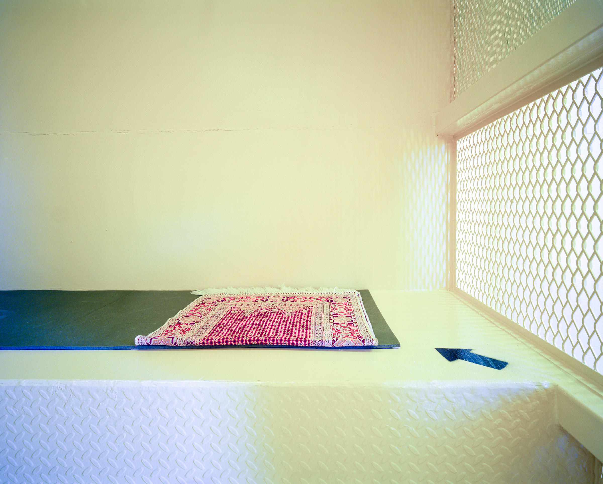 Debi Cornwall’s “Prayer Rug with Arrow to Mecca, Camp Echo, February 2, 2015.”