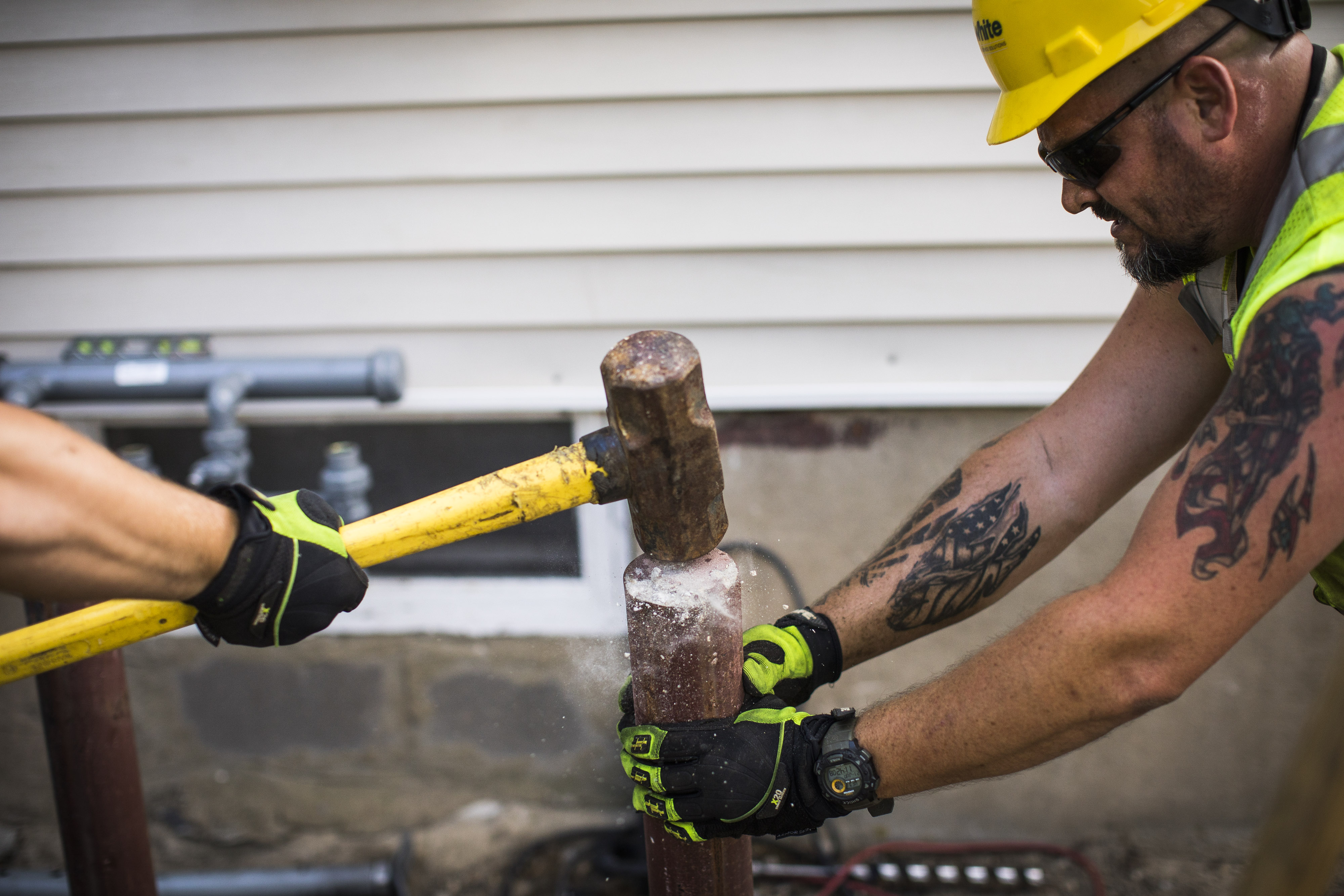 Jeffrey Sweeney (right) works on a construction site in Manchester. Sweeney, 39, an Army National Guard veteran, injured his spine when an improvised explosive device blew up his truck in Iraq in 2011. Four months after neurosurgery at the West Roxbury VA in 2013, Sweeney was still suffering disabling back pain and Manchester doctors were increasing his pain medications. It was later discovered that a surgical screw has been inserted into a nerve. A private surgeon removed the screw.