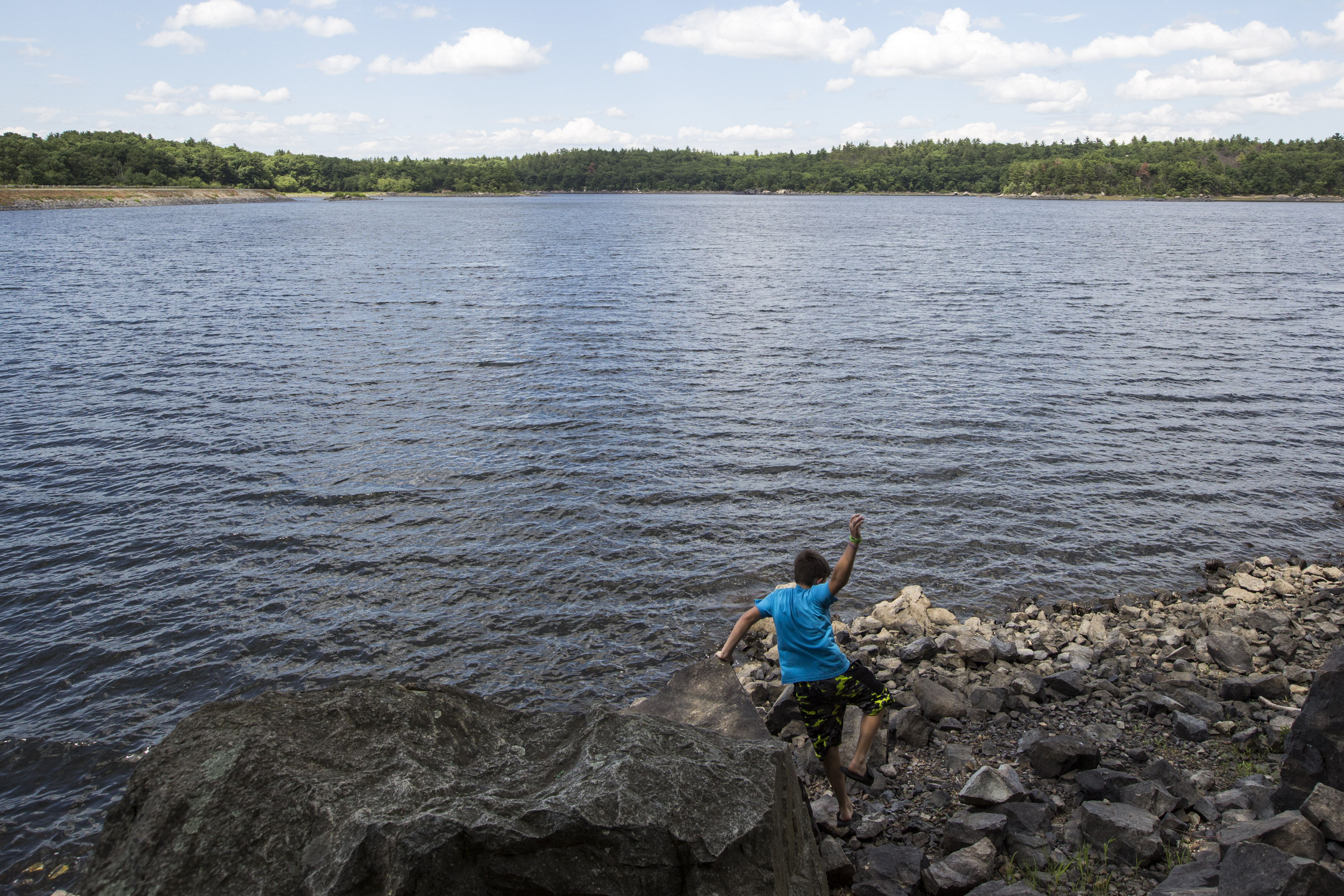 A boy played on the rocks of the shore at Walden Pond in Saugus.