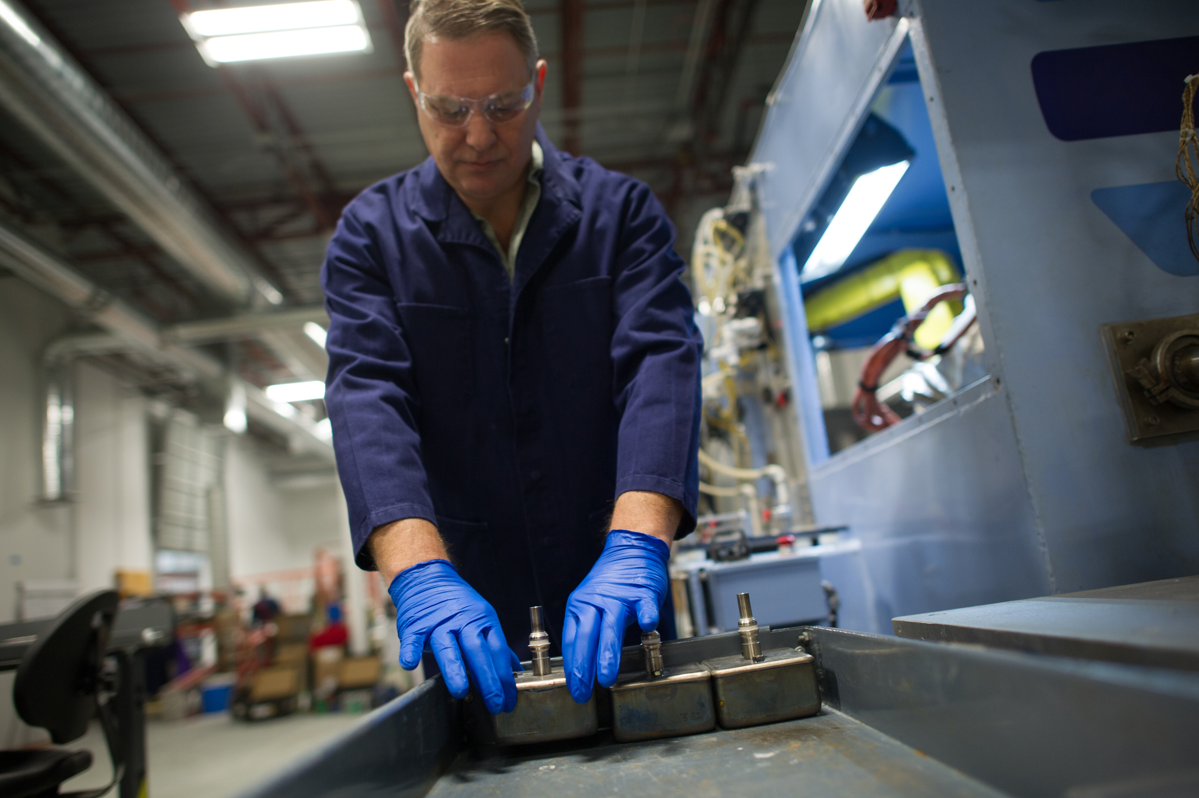 An Ambri process engineering technician, Henry Phillips, placed a battery cell alongside other cells in a power core.