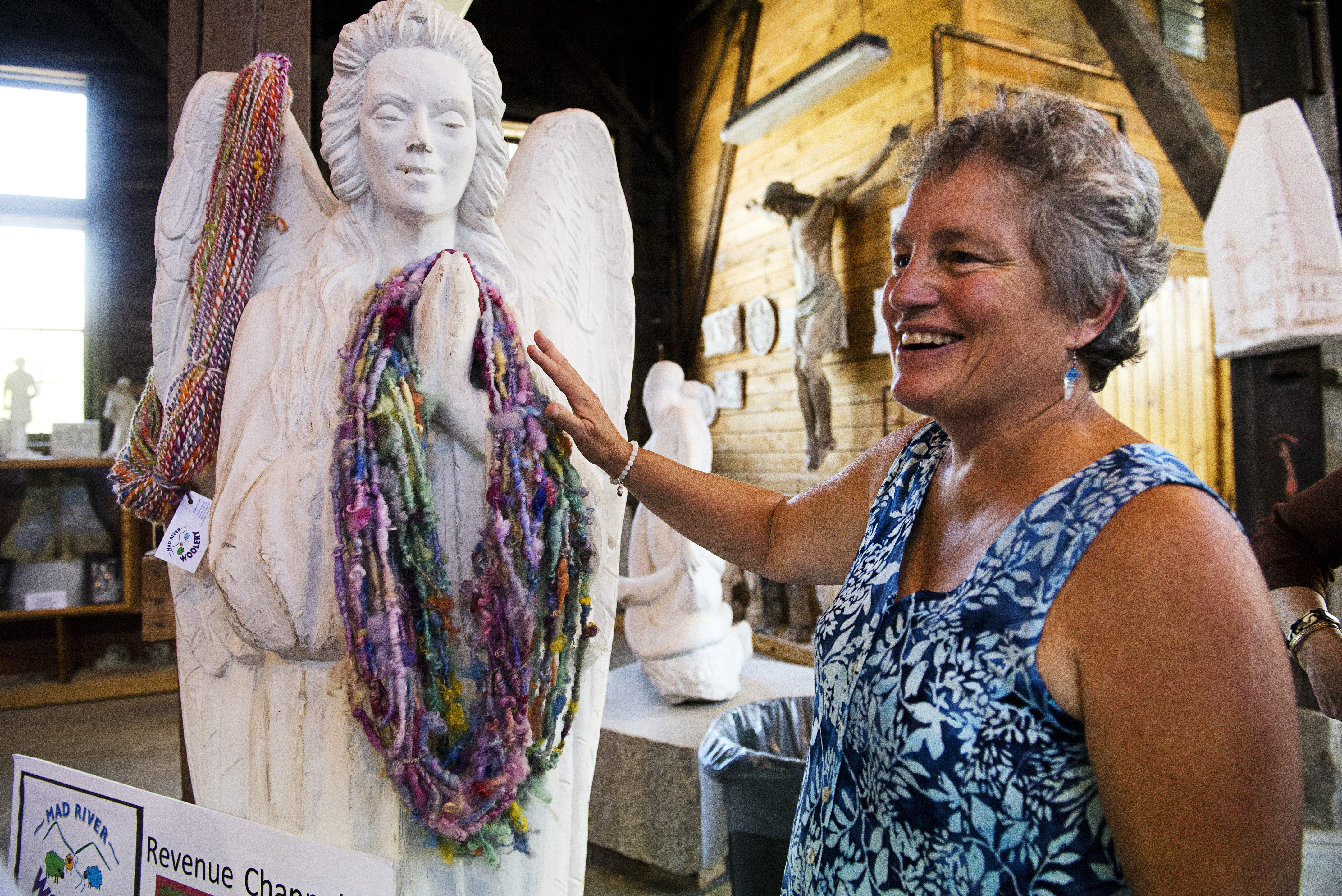 Vee Lynch of Mad River Woolery stood with her work draped over a statue during the Central Vermont Road Pitch at the Vermont Granite Museum in Barre, Vt.