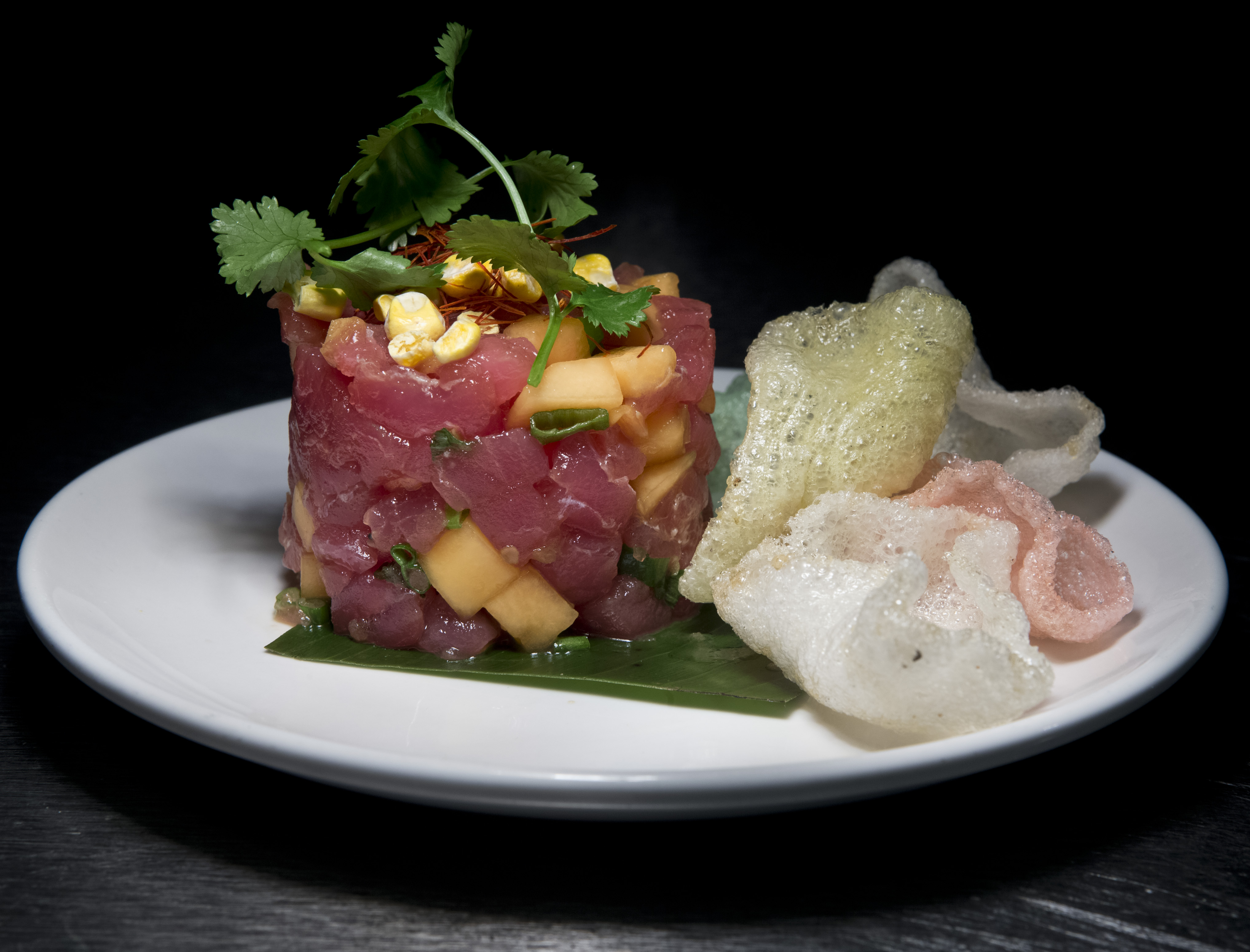Tuna tartare, accompanied by melon, lemongrass, chile threads, and shrimp chips.