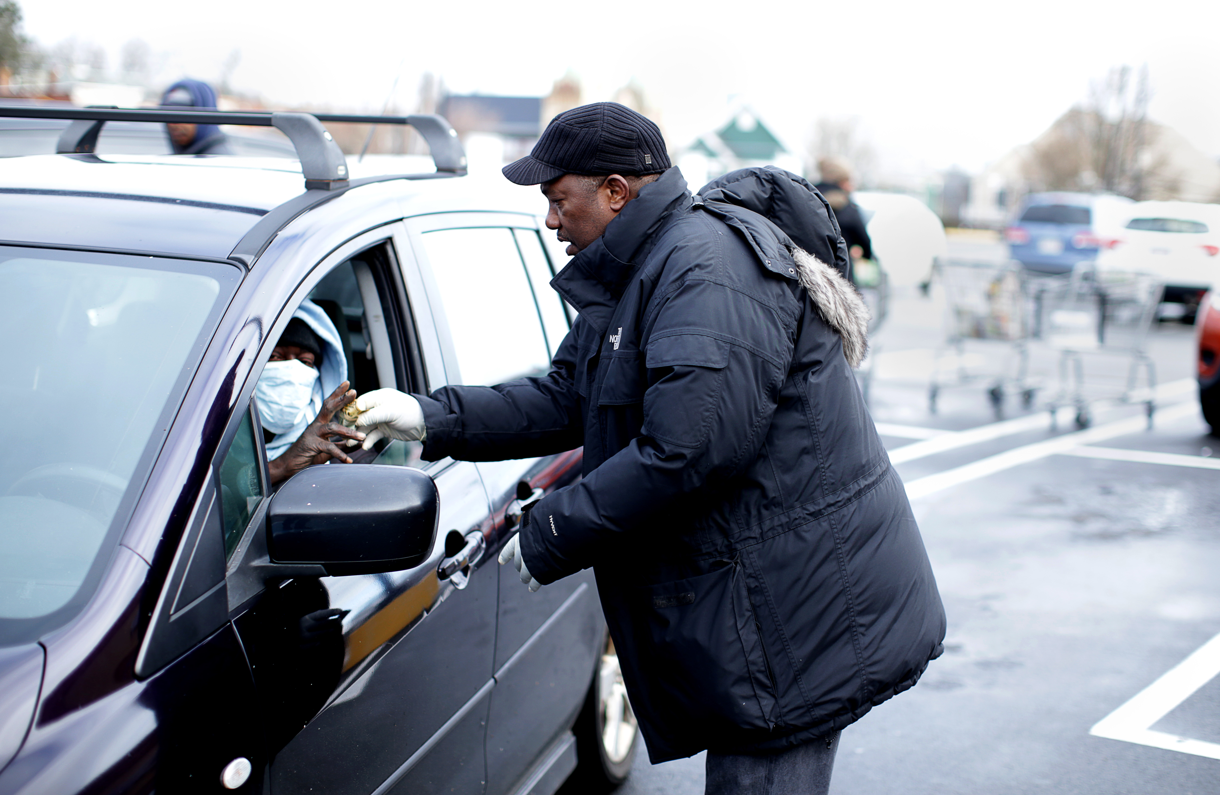 Pastor Miniard Culpepper handed out $10 bills to people in Roxbury on Tuesday.