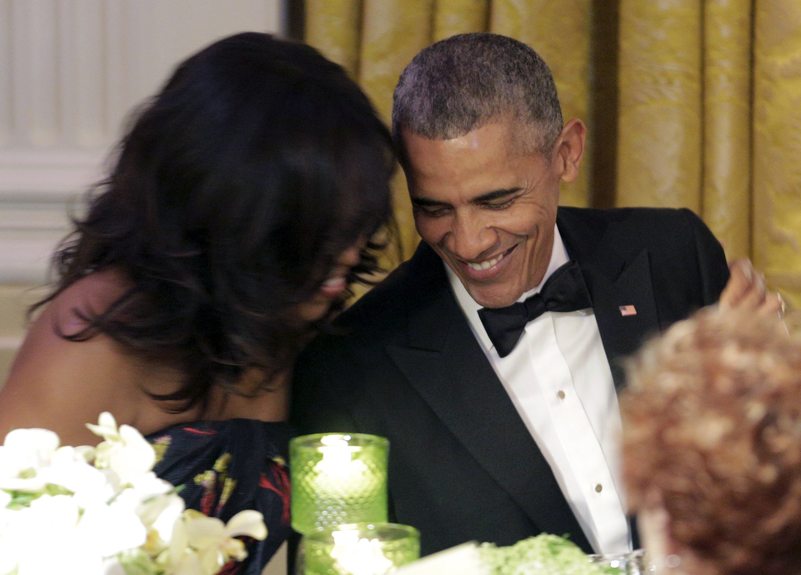 Barack Obama and first lady Michelle Obama hug as the Prime Minister of Canada Justin Trudeau made a toast.