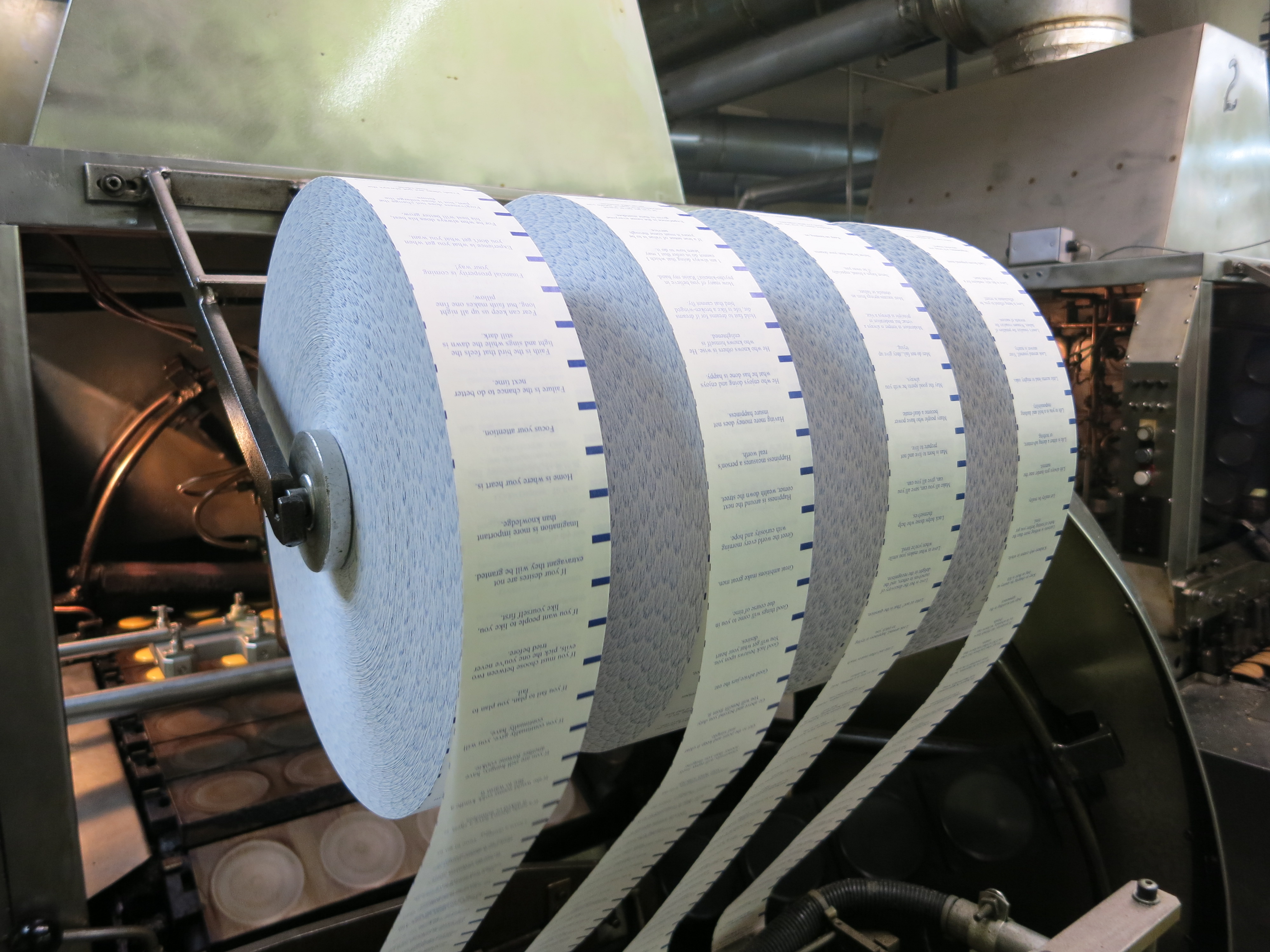 Fortunes on rolls of paper were sliced off mechanically at Wonton Food's Fortune Cookie Factory.