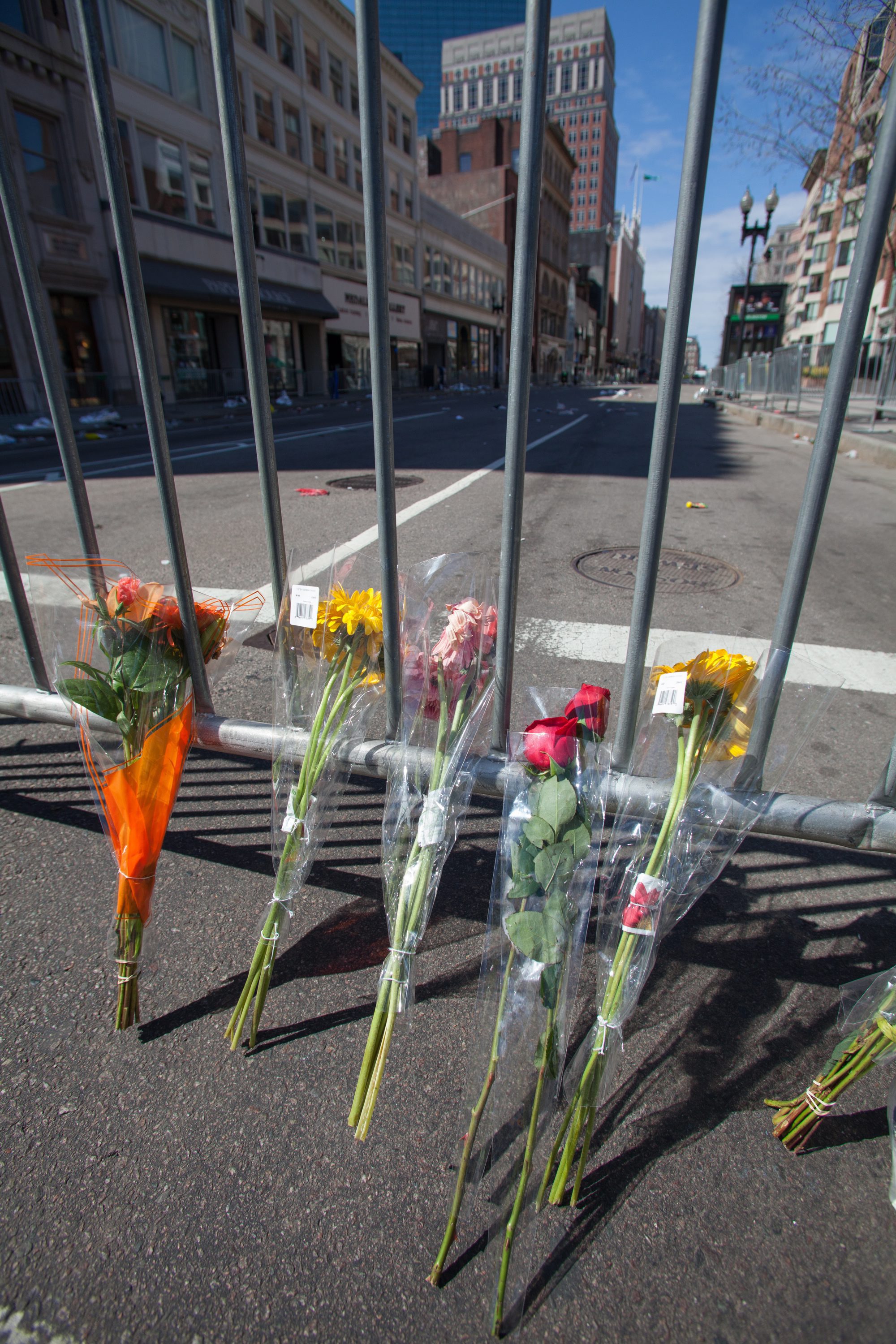 Flowers lay against a barricade near the finish line of the Boston Marathon and the site of deadly twin bombings.