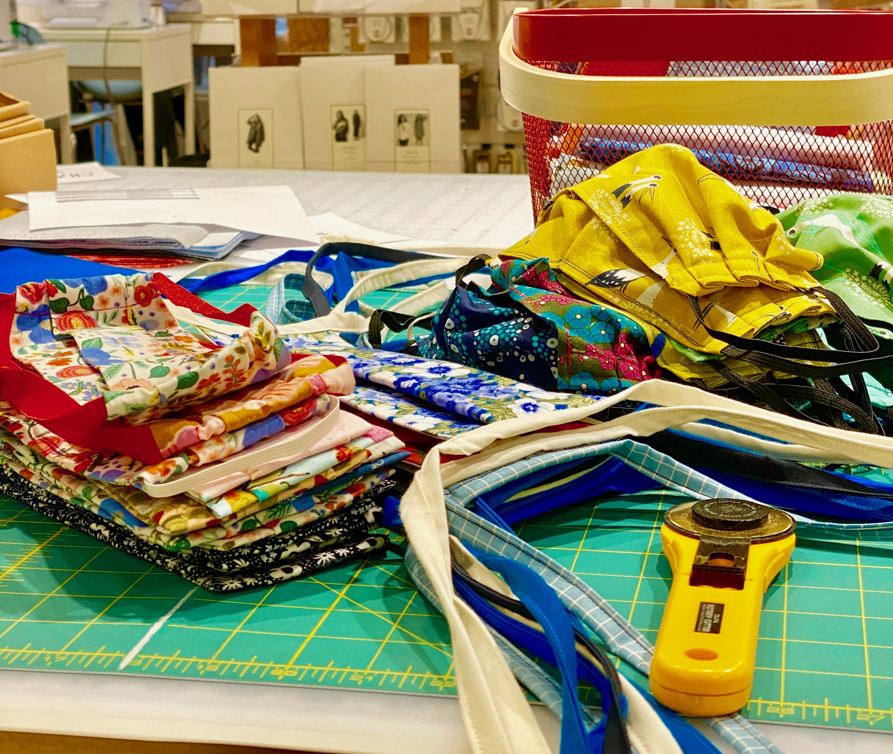 A pile of masks that will be donated to people in the Boston area sit on the counter at Gather Here, a shop in Cambridge.