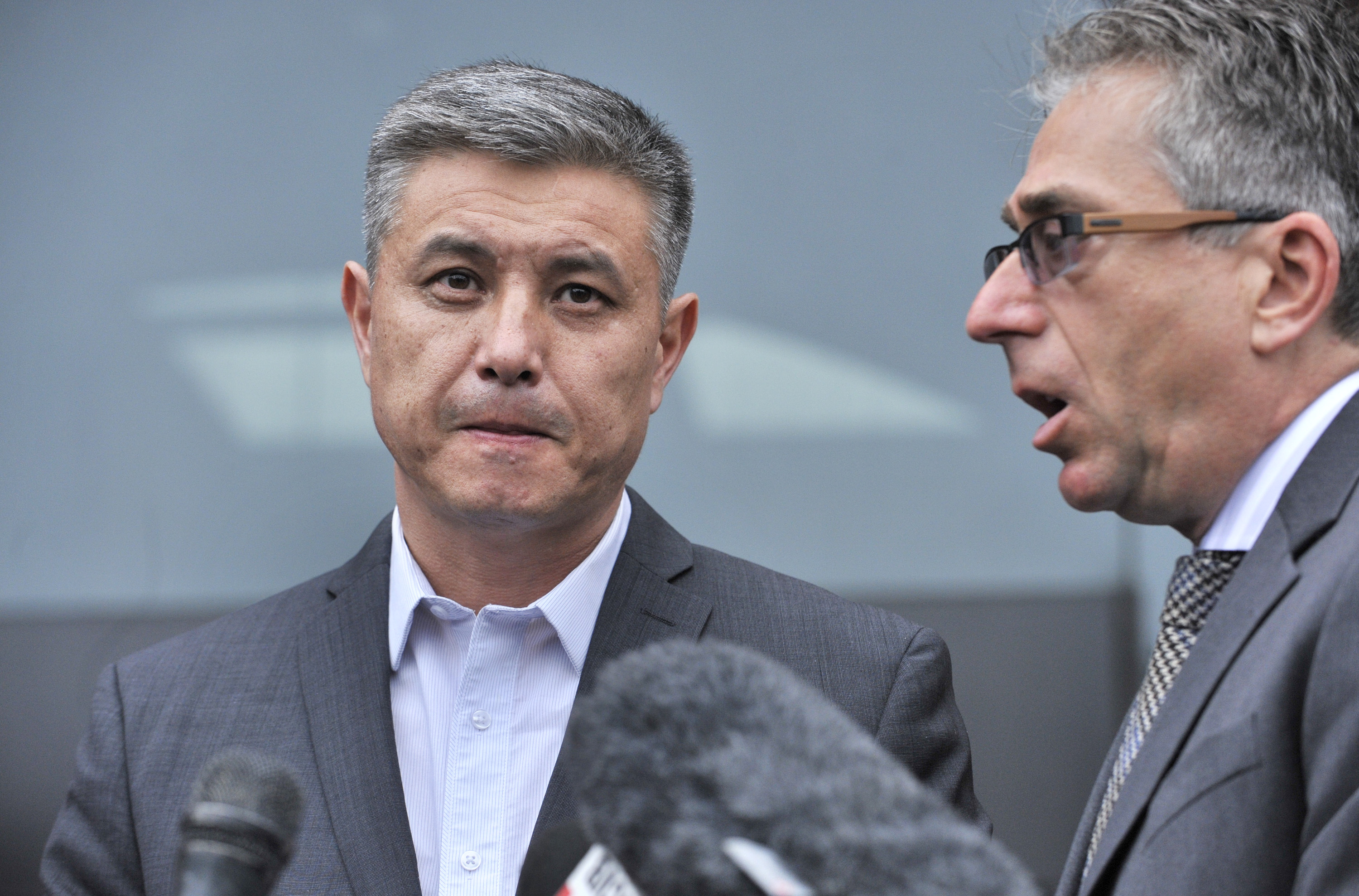 Murat Kadyrbayev (left), father of Dias Kadyrbayev, spoke to reporters through interpreter Alexander Tetradze after his son was sentenced to six years in prison.