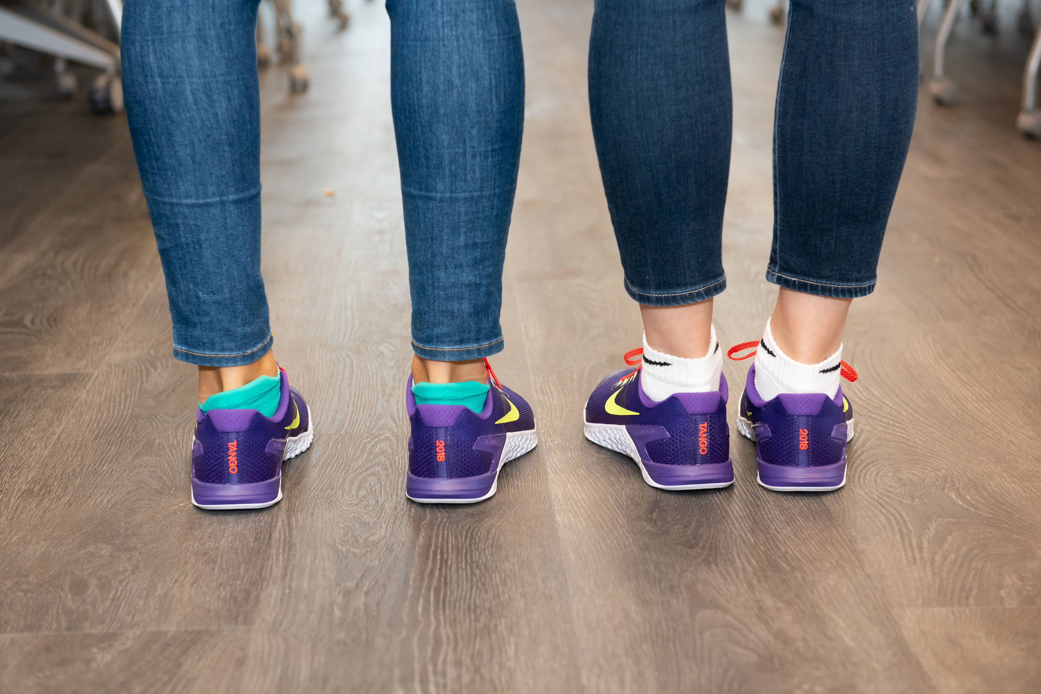 Two Tango employees wearing shoes given this year to workers to mark the company’s move to its new space at 100 Binney St.