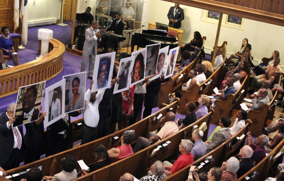 Photos of the victims of the shooting at Emanuel African Methodist Episcopal Church are held during a vigil at the Metropolitan African Methodist Episcopal Church in Washington, D.C.