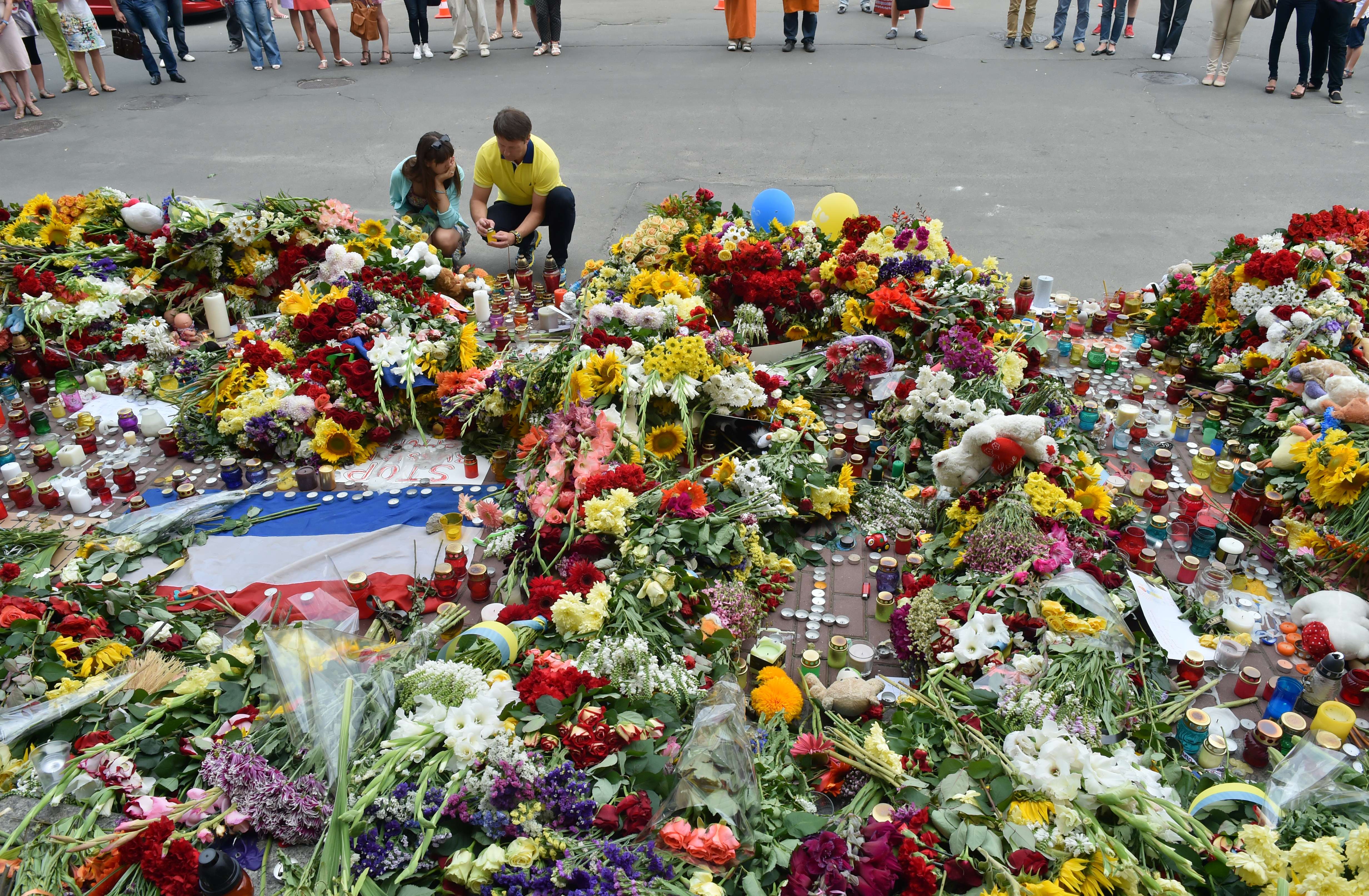 People laid flowers and lit candles in front of the Dutch Embassy in Kiev after the crash of the Malaysian jetliner.