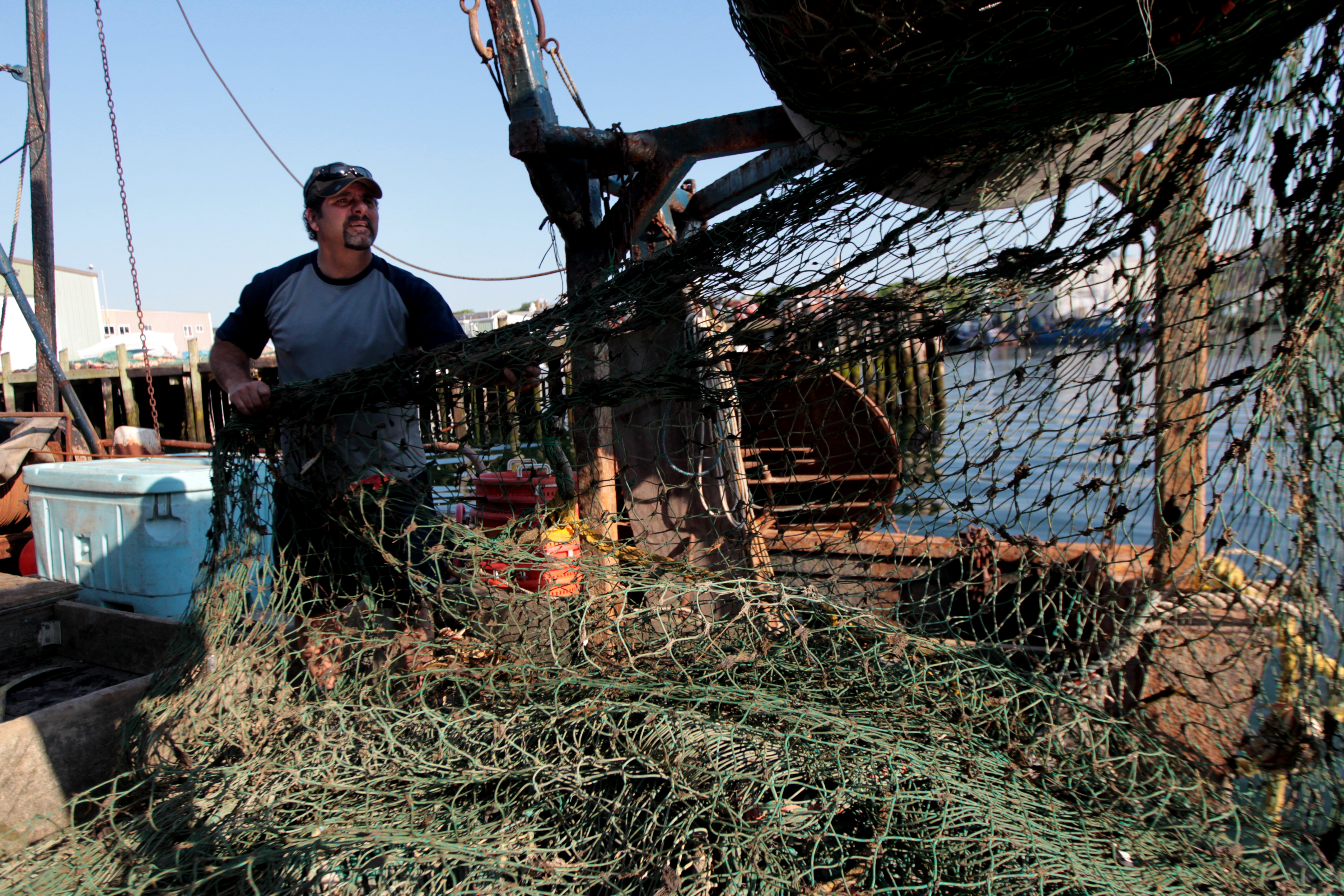 Al Cottone adjusts gear on his boat in Gloucester Harbor.