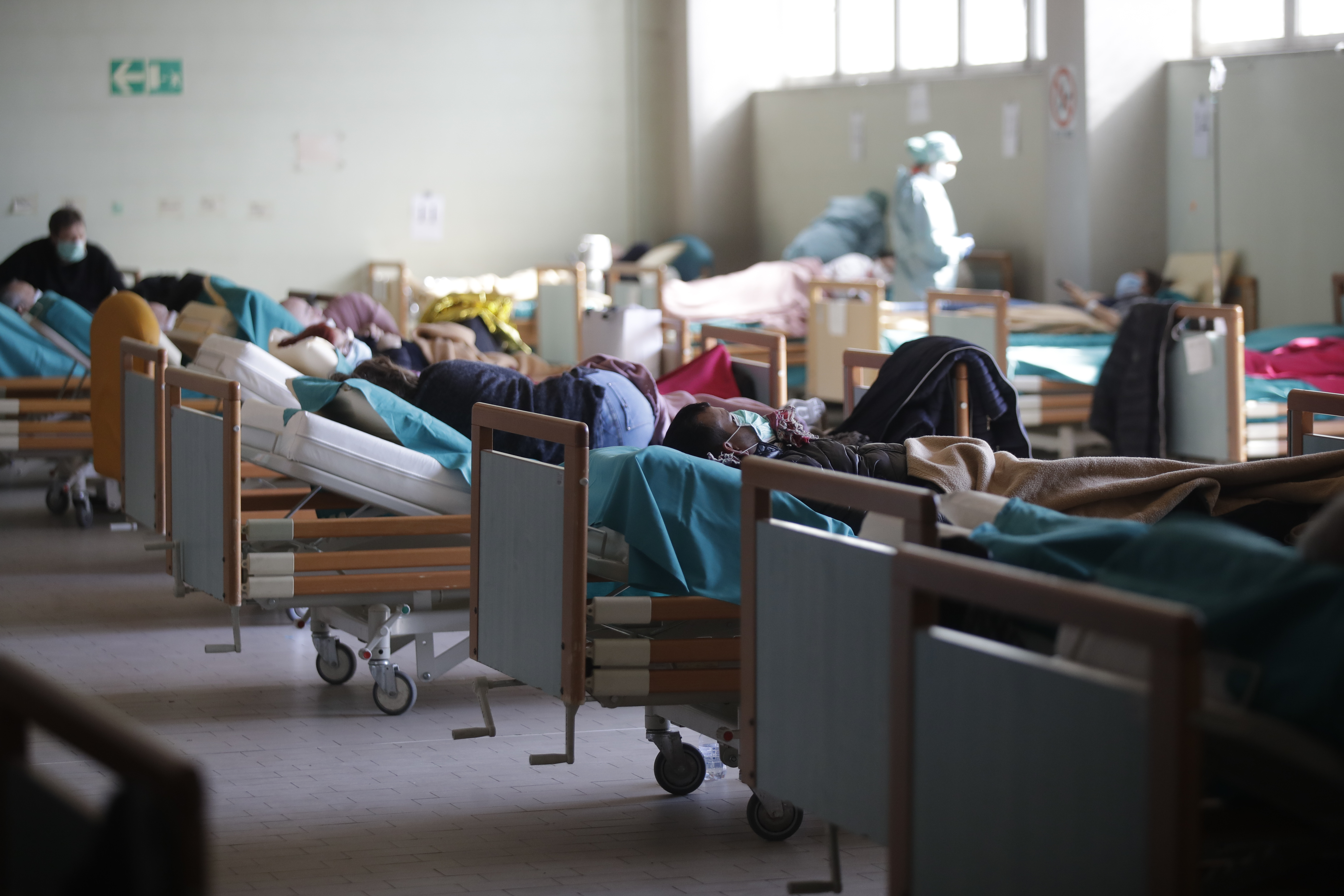 Patients lie on beds at one of the emergency structures were set up to ease procedures at the Brescia hospital, Italy on Monday.