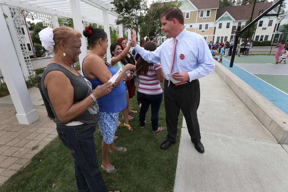 Martin Walsh receives a high five from Maria Bruno, 11, as he introduces himself during a campaign stop at the Franklin Hill community playground.