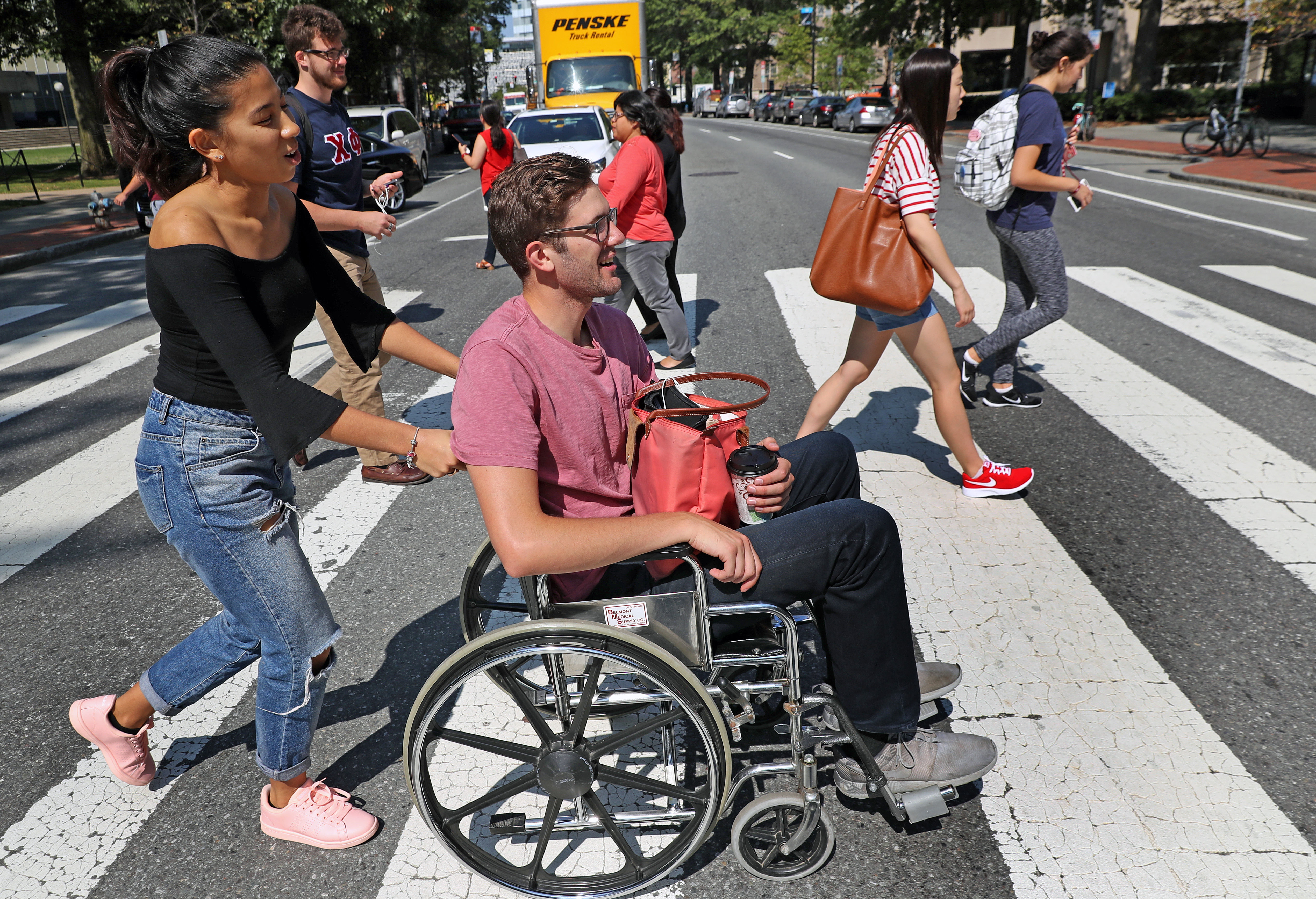 MIT students Andrew Hall in wheelchair got a push by Helen Abadiotakis across Massachusetts Ave. in a MIT PPAT class.