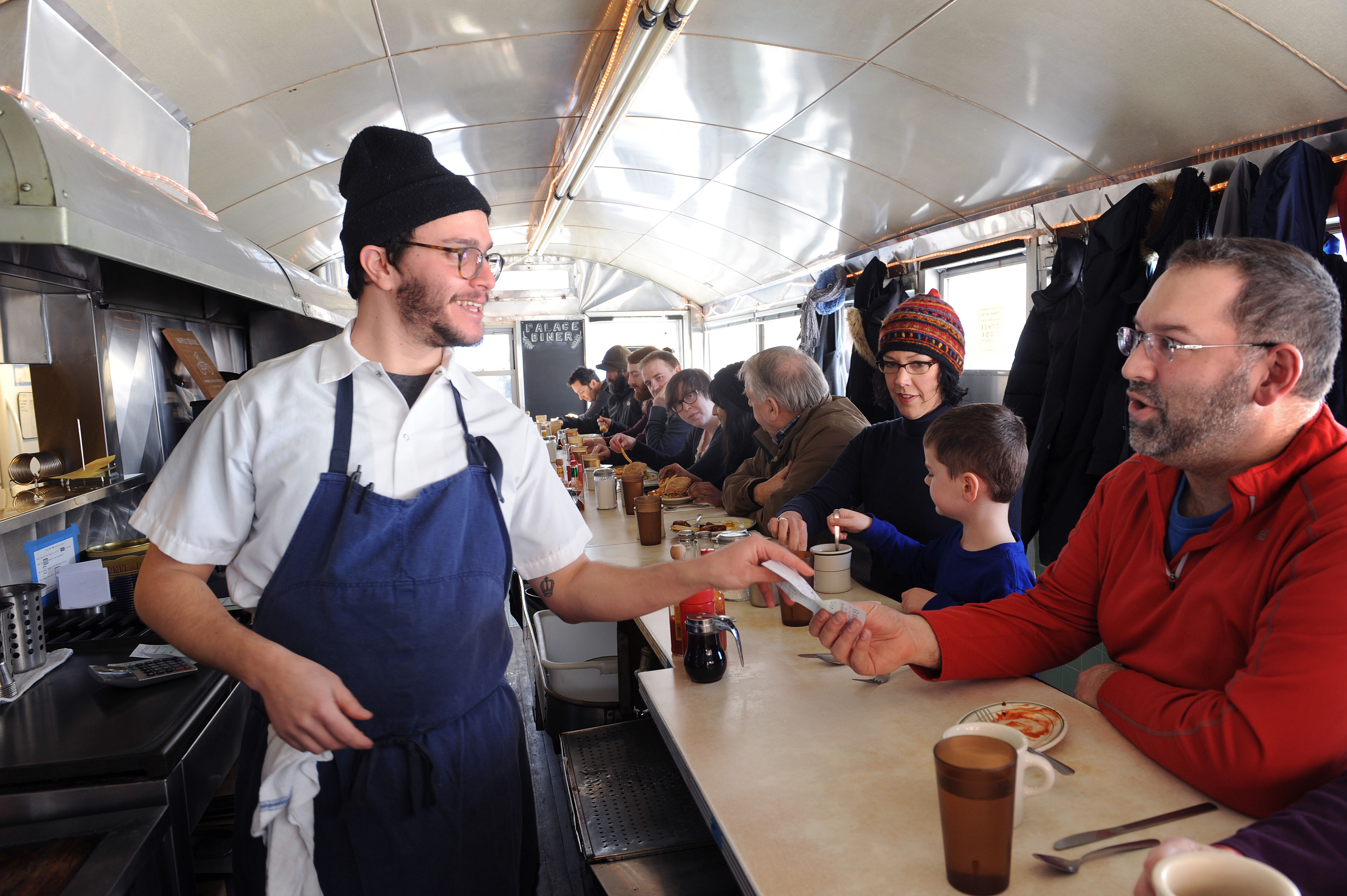 Greg Mitchell handed the check to Jon Jacques at the Palace Diner in Biddeford. Mitchell is co-owner of Maine's oldest diner.