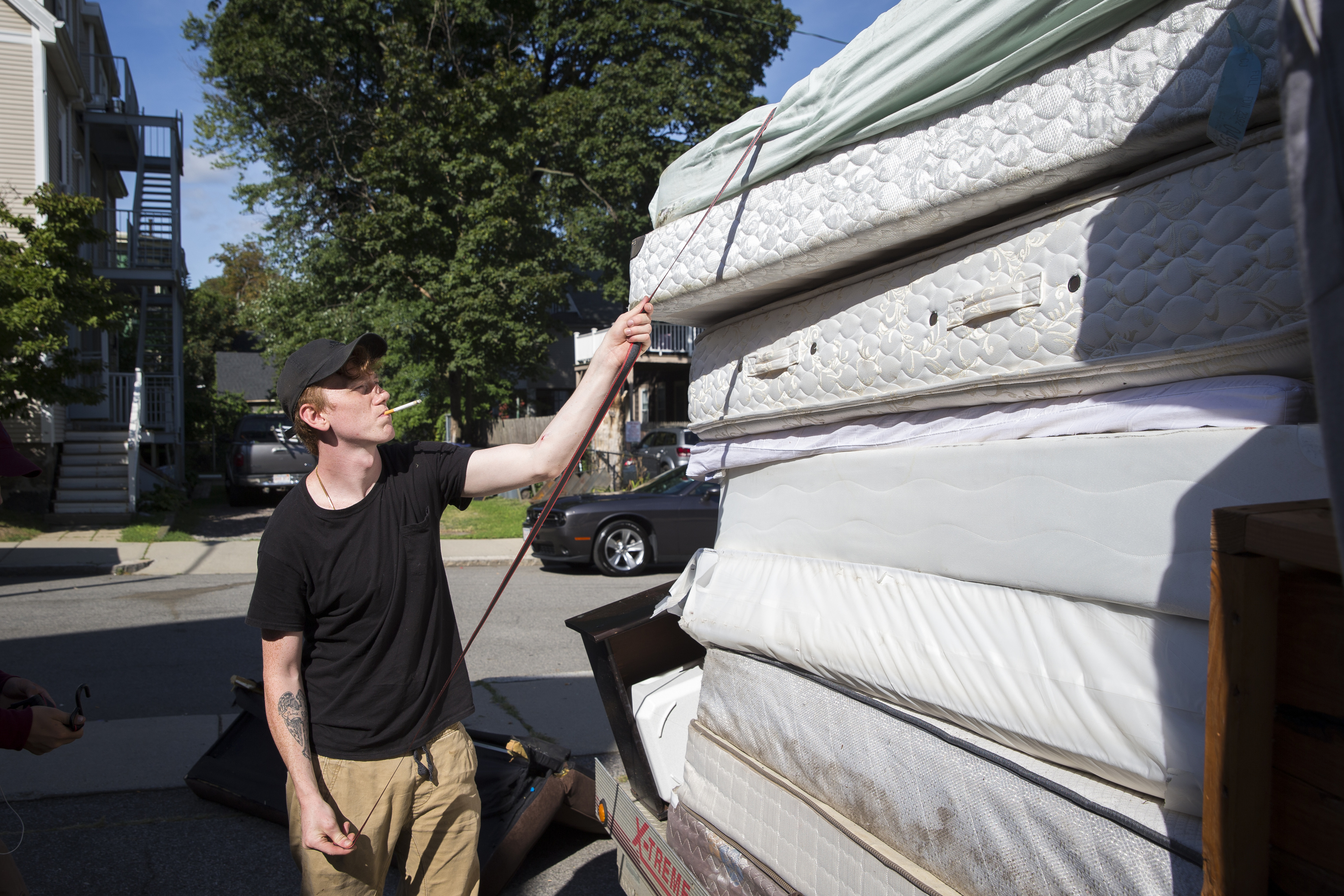 Seth Jones, 21, of Sanford, Maine, strapped down mattresses to a trailer full of of disposed belongings.