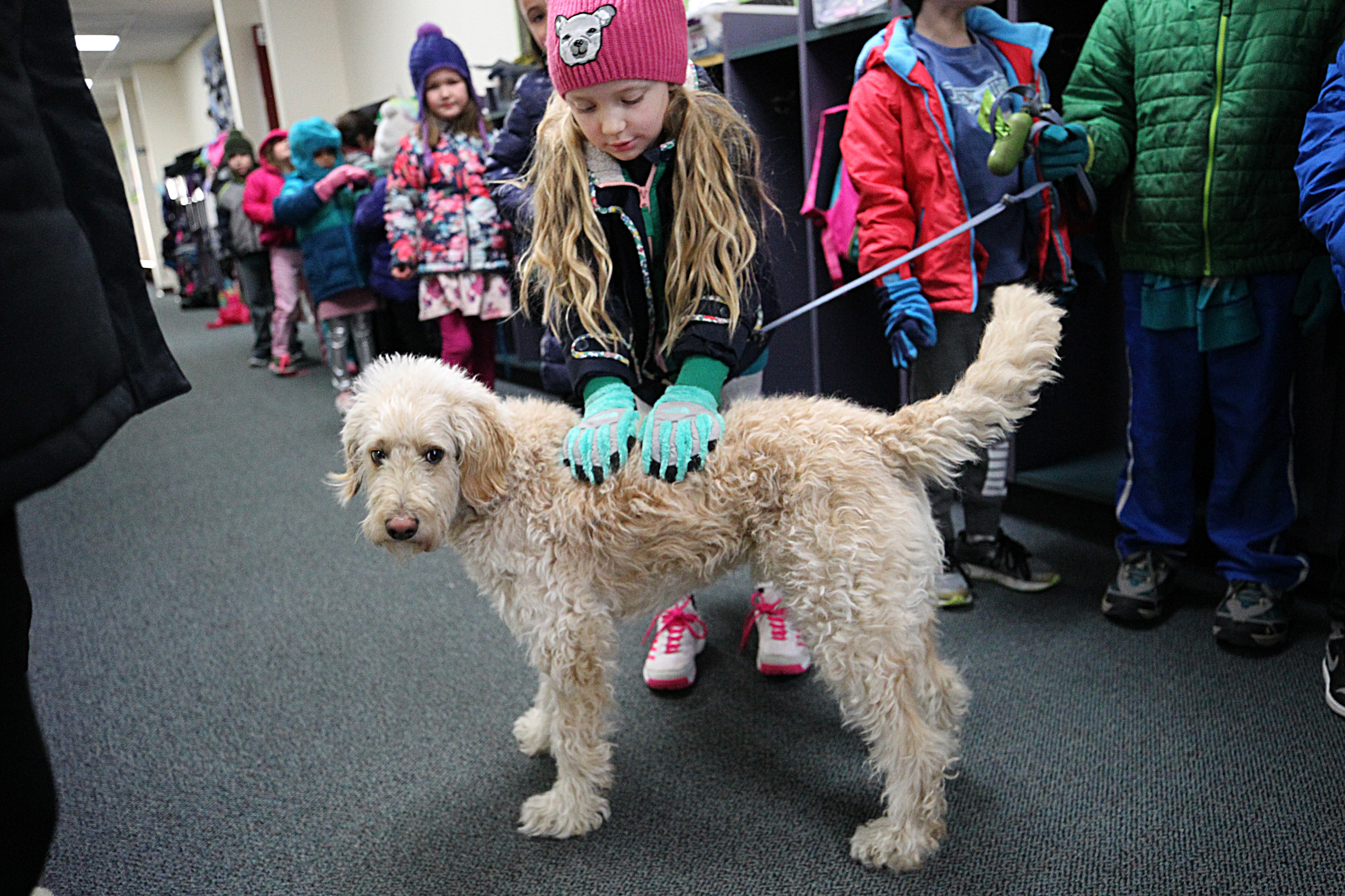 Gwendolyn pats Oscar as the first-graders head out for recess.