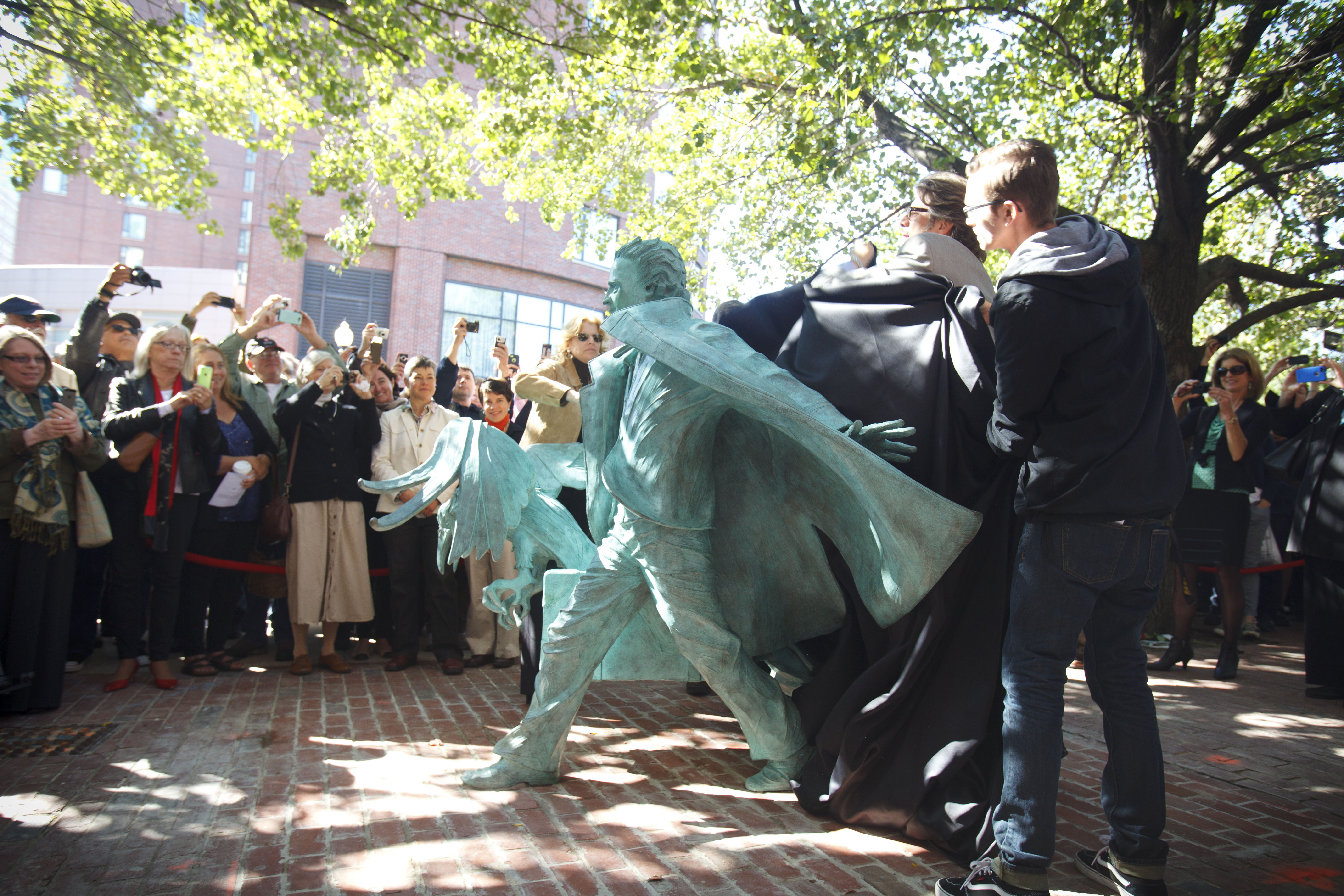 The bronze Edgar Allen Poe’s briefcase overflows with the symbols that made him famous: a larger-than-life raven, and a human heart.