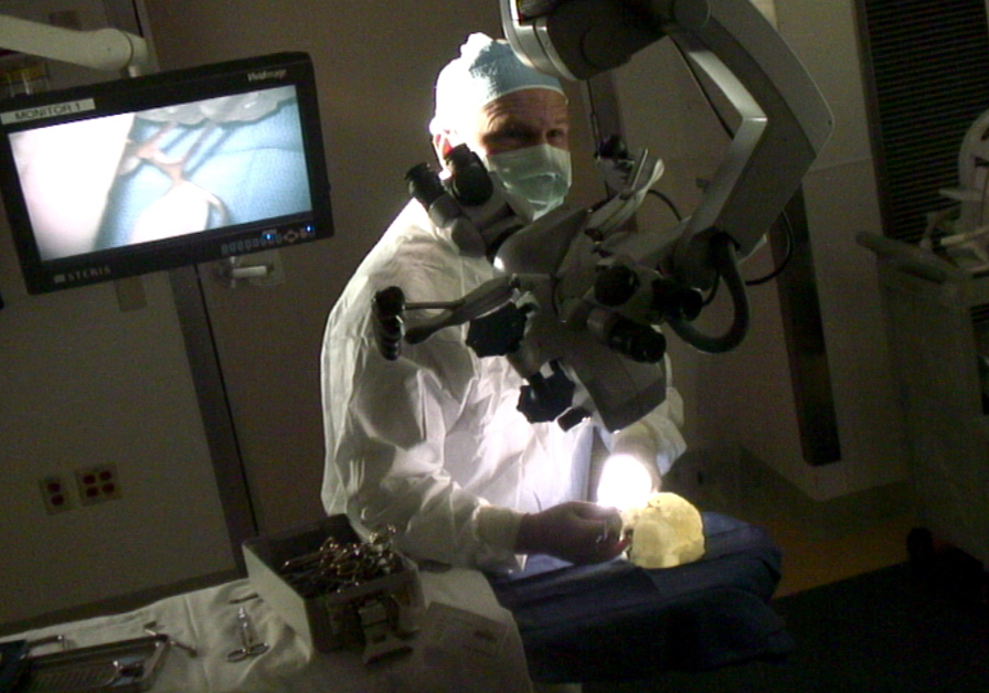 Dr. Joseph Madsen conducted a mock operation: Masked and gloved in an operating room, scalpel in hand and microscope overhead, he carefully made his cuts into the model of Myalynn Ranson’s brain.