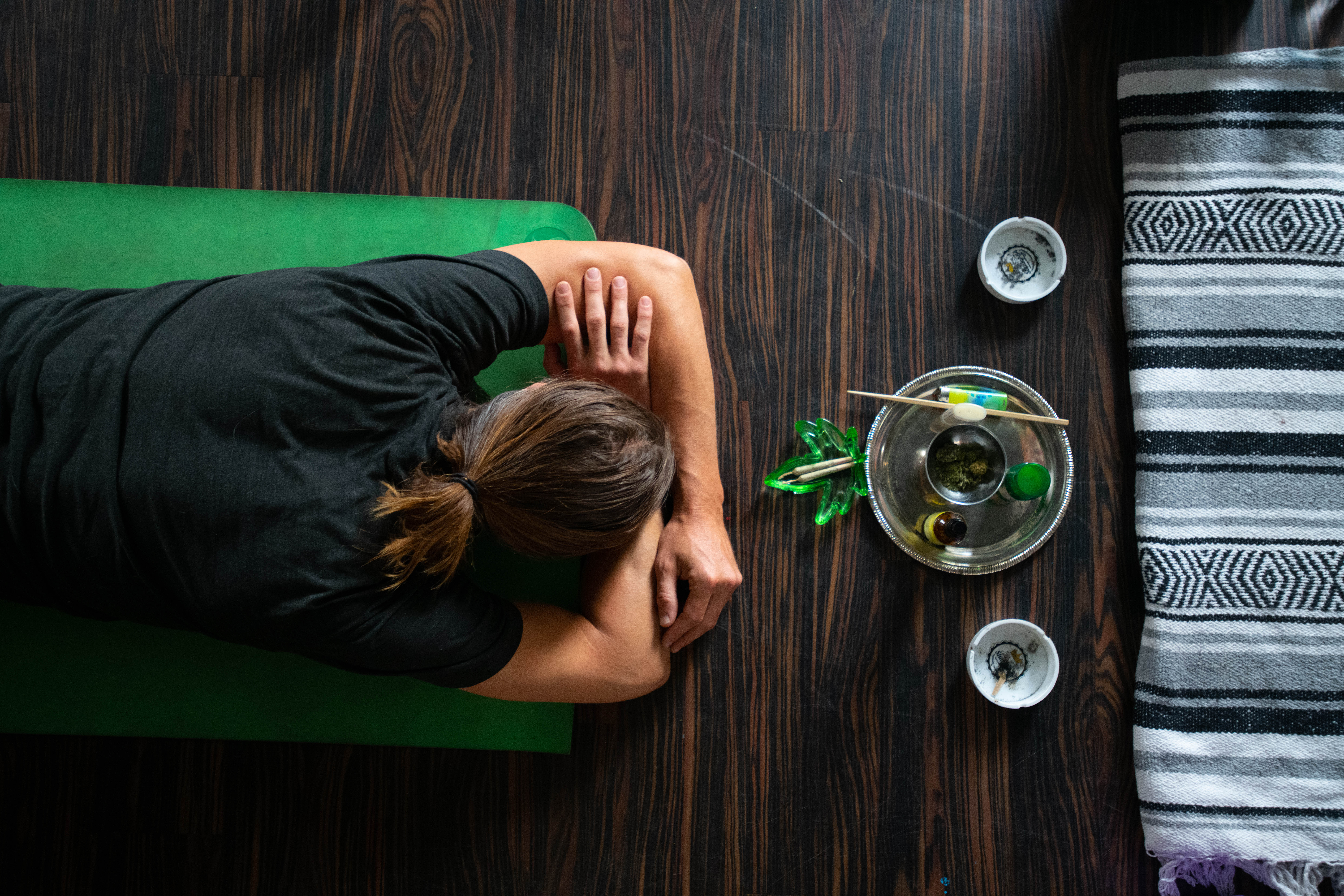 Caleb Berry reclined on his yoga mat next to cannabis joints during a Secret Stash yoga session Sunday.