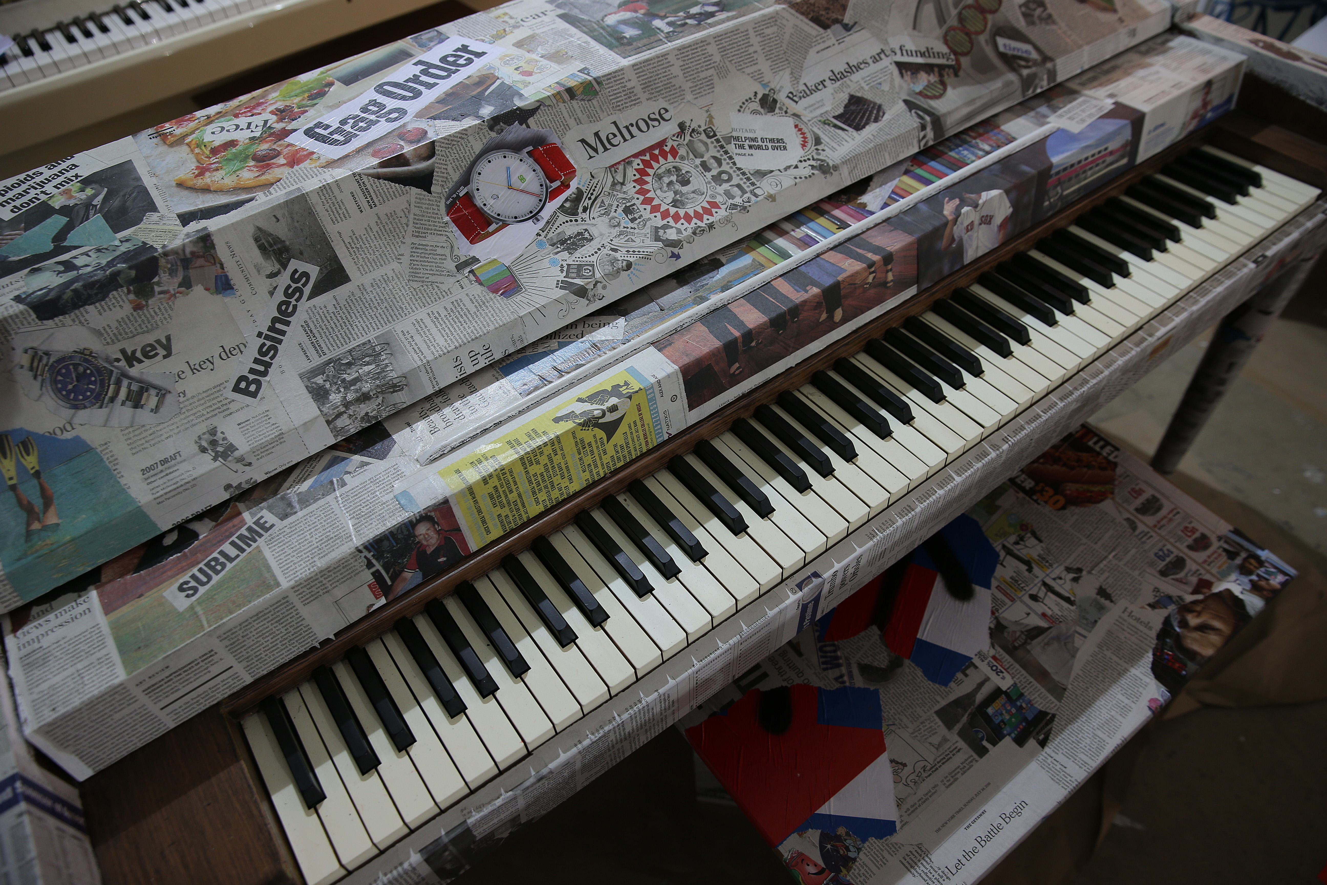 Pages and scraps from The Boston Globe were used to cover one of the pianos.