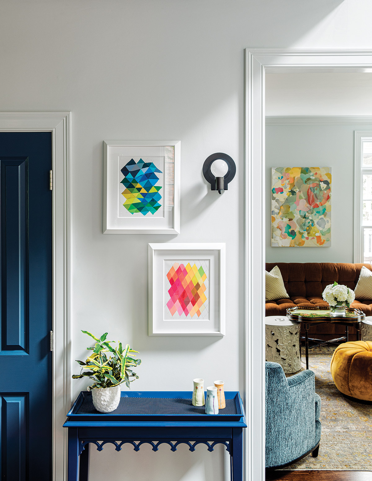 In the entry, a blackened steel sconce by John Beck Steel hangs above a lacquered console table by Oomph.