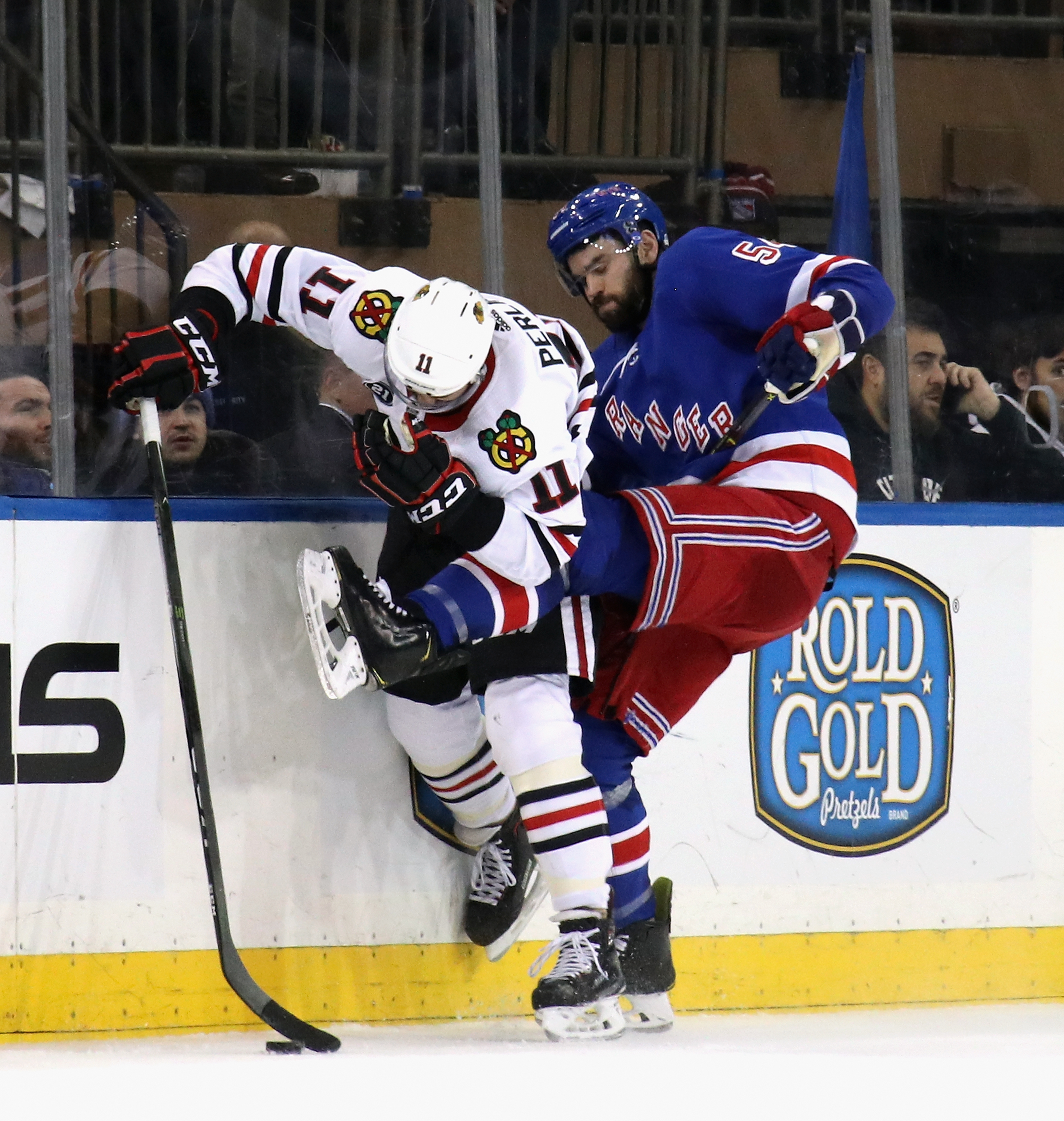 This is the kind of action fans remember seeing from former Bruin defenseman Adam McQuaid (54), now checking Blackhawks Brendan Perlini for the New York Rangers.