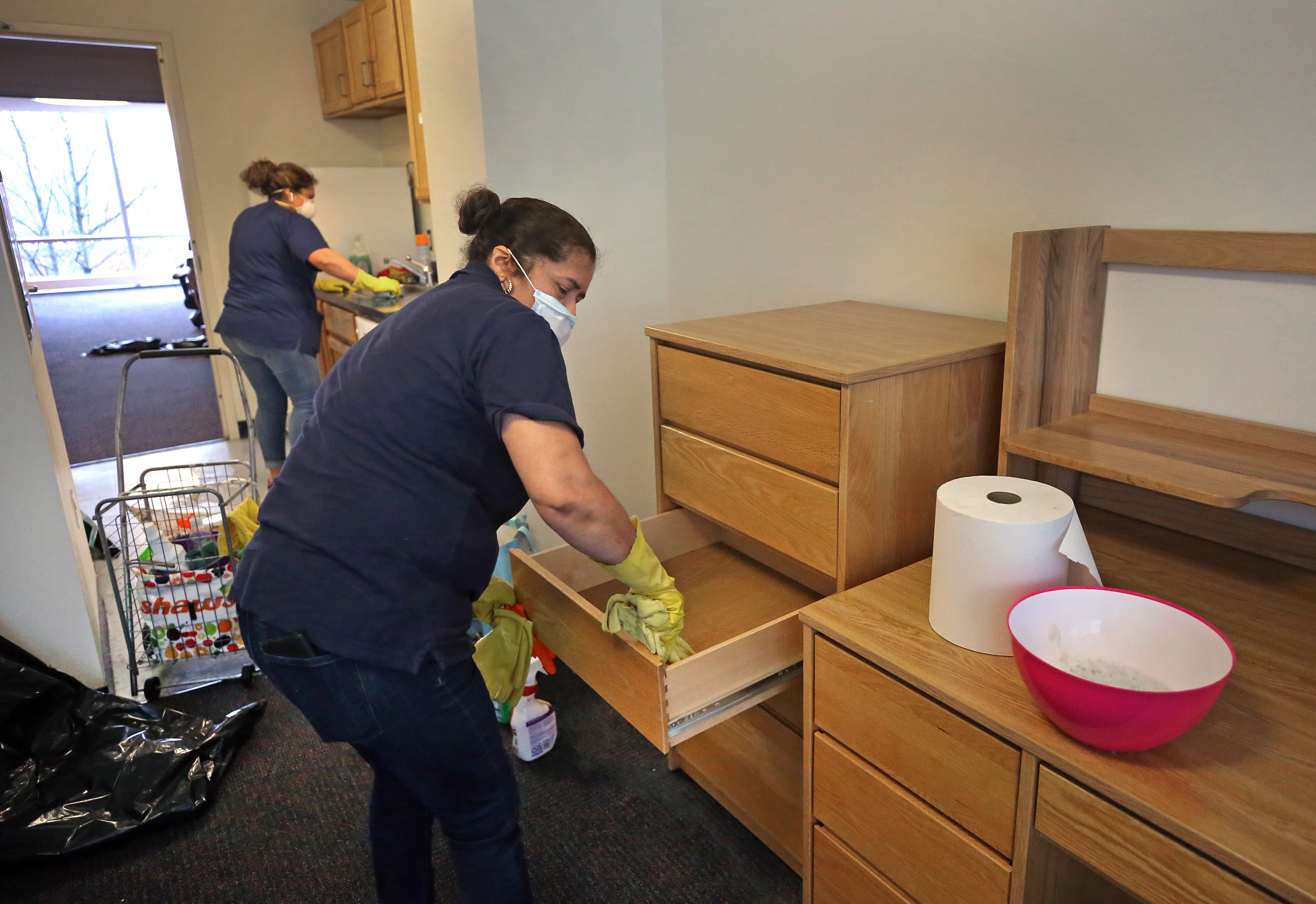 Cleaning company employees clean a living space in a dorm unit at Northeastern University.