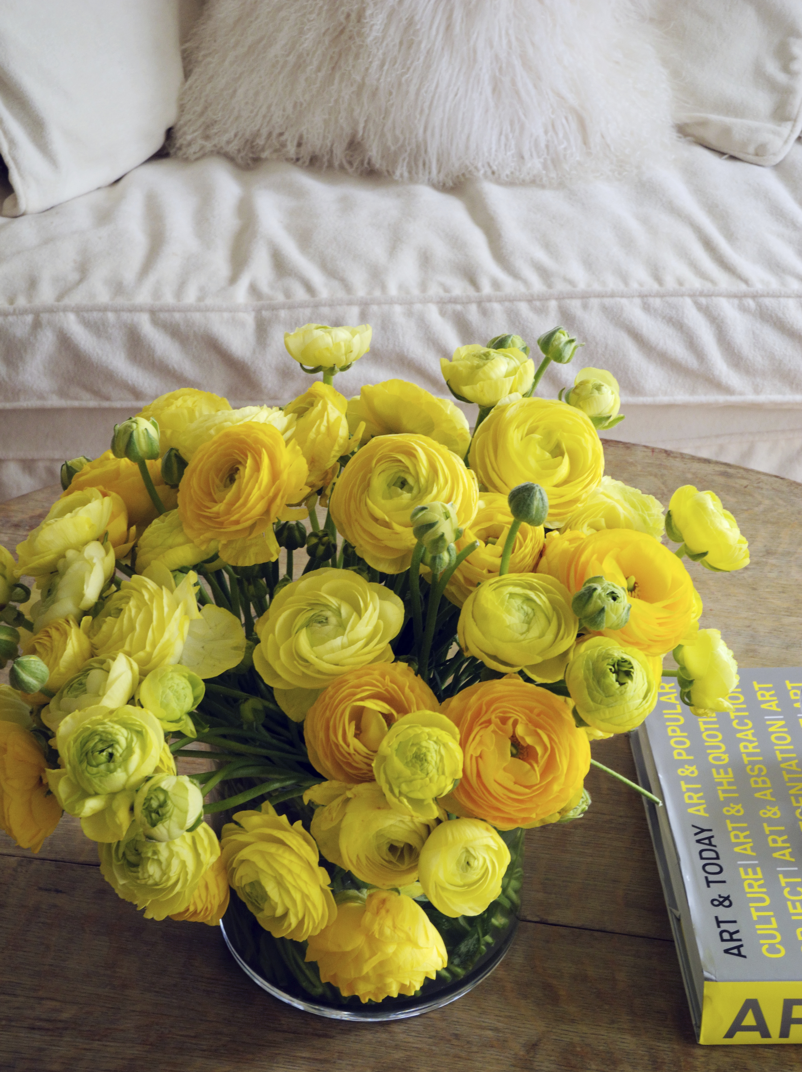 Shades of yellow are increasingly popular in home decorating and can bring a welcome burst of warmth to cooler, neutral spaces, as seen in this tabletop decorated with a vibrant yellow floral arrangement by New York-based interior designer Young Huh.