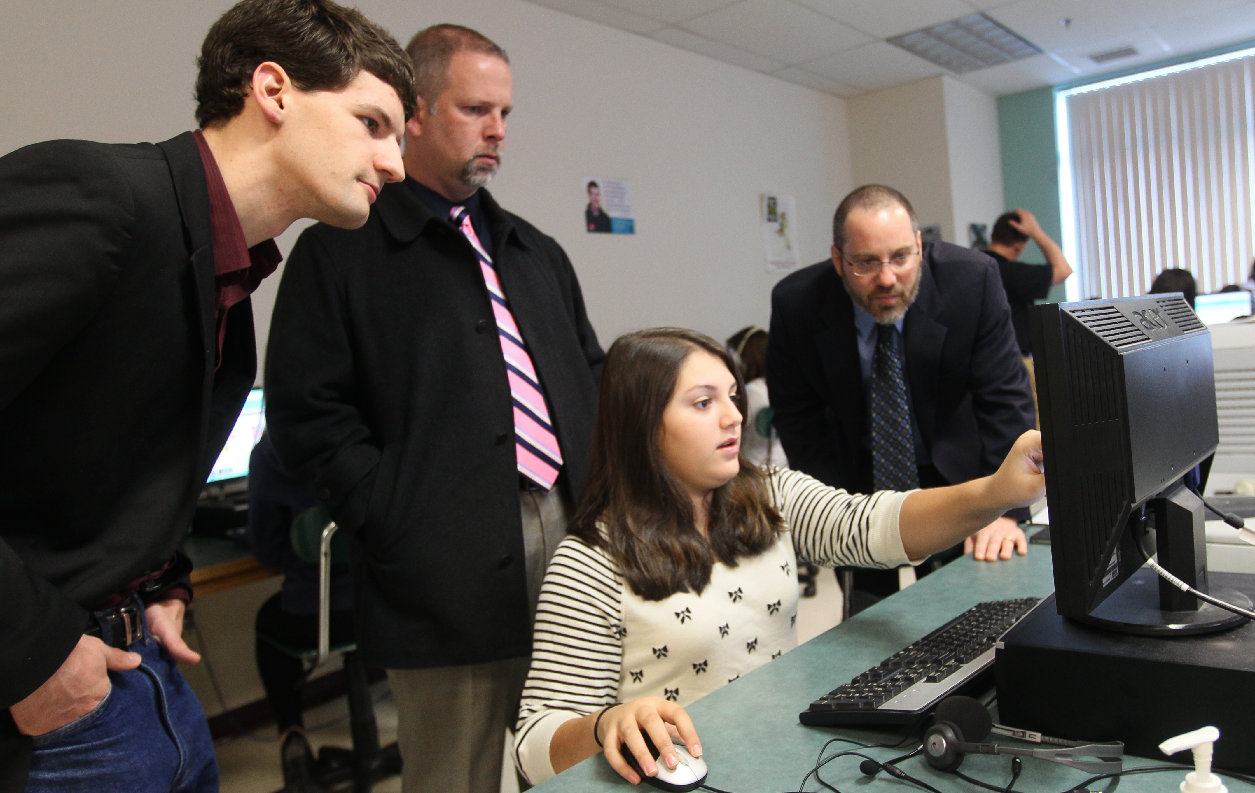 Littleton seventh-grader Christina Tsillas shares her “Hour of Code’’ project with (from left) school board member Alex Pratt and school principals Scott Bazydlo and Mark Branco.