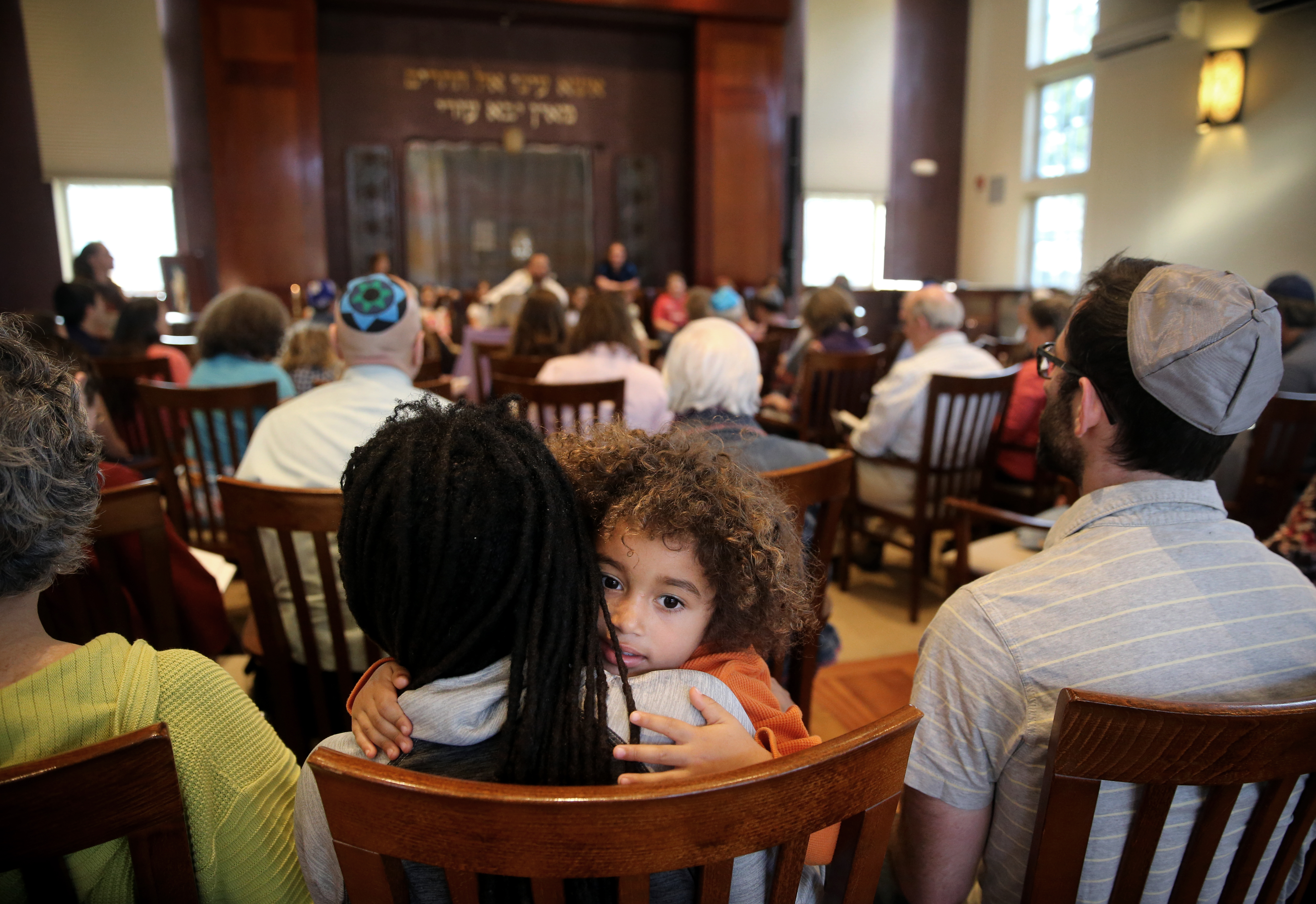 Ezrah Fishman, 3, sat with his parents during a Kabbalat Shabbat service in May.