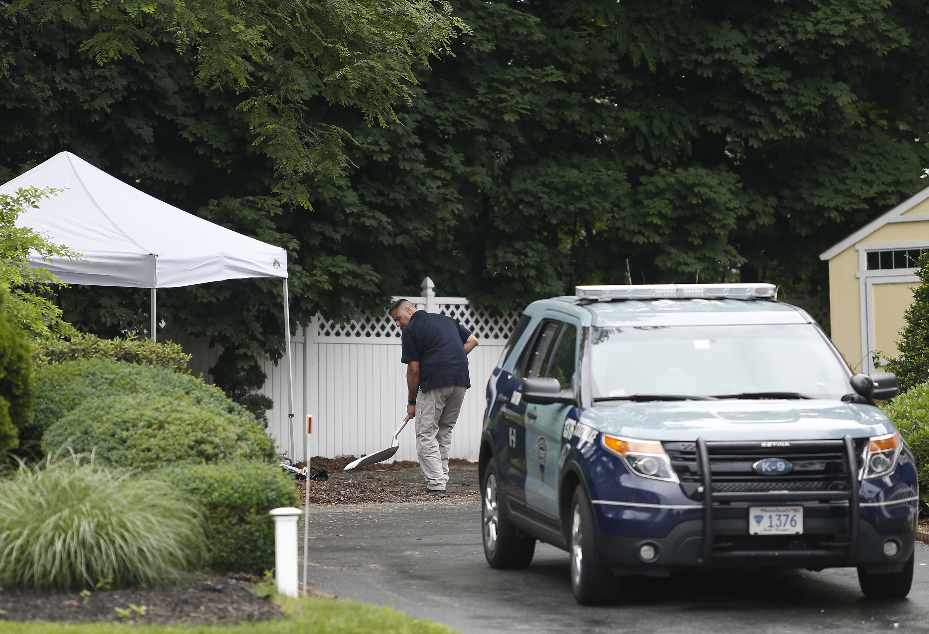 An investigator sifted through dirt in the side yard of 15 Lakeshore Drive in Wakefield, the site of a former sober home.