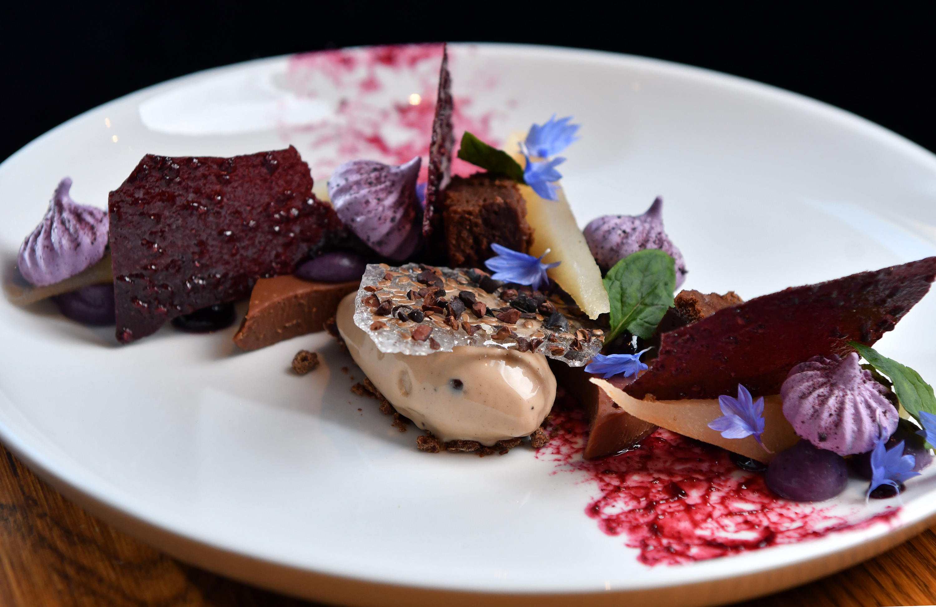 Malted milk chocolate custard with Calvados-poached pears and cocoa-nib praline ice cream.