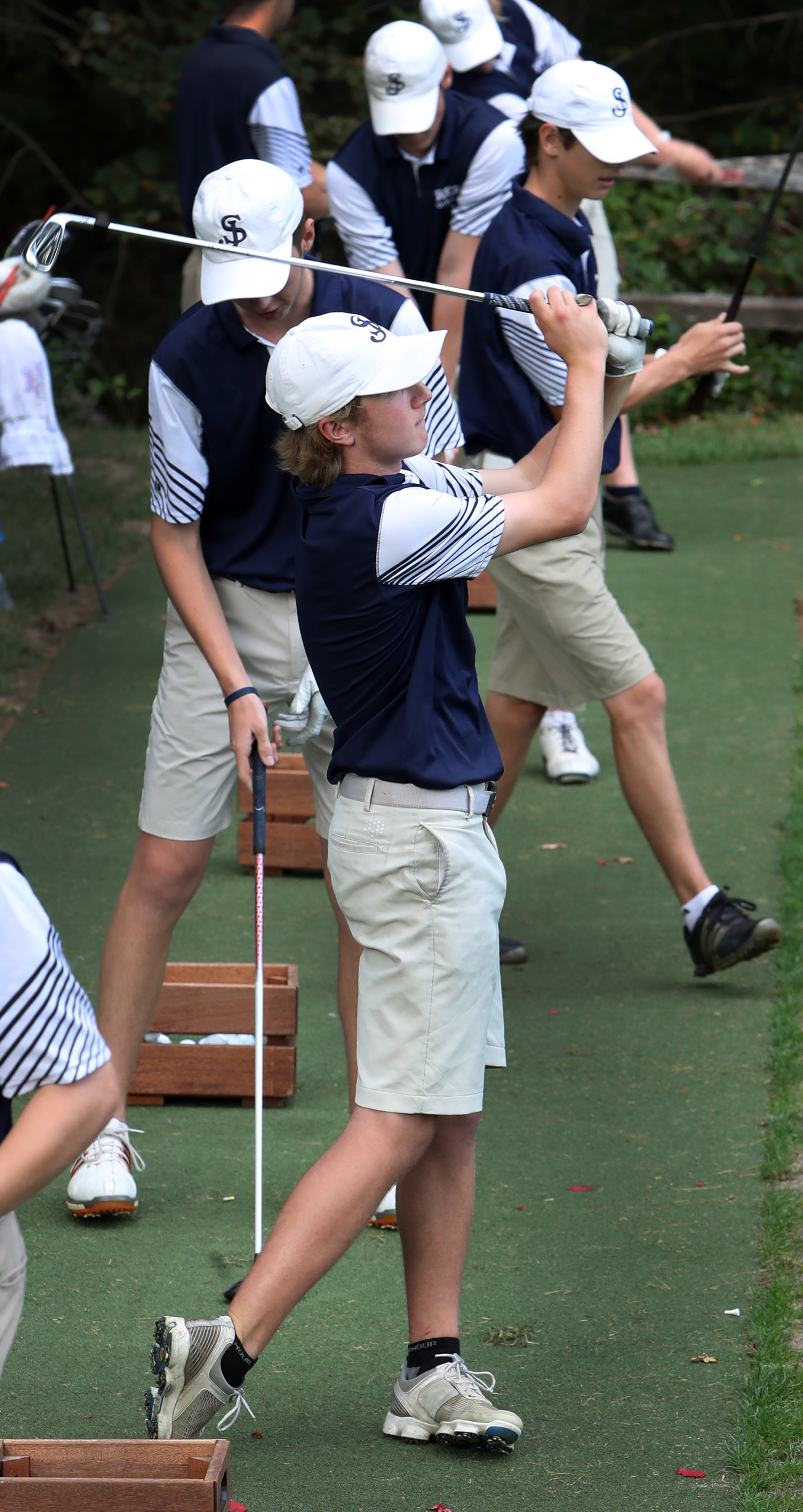 Drew Simons, the St. John's golfers’ rising star, tees off on the practice range before the match.