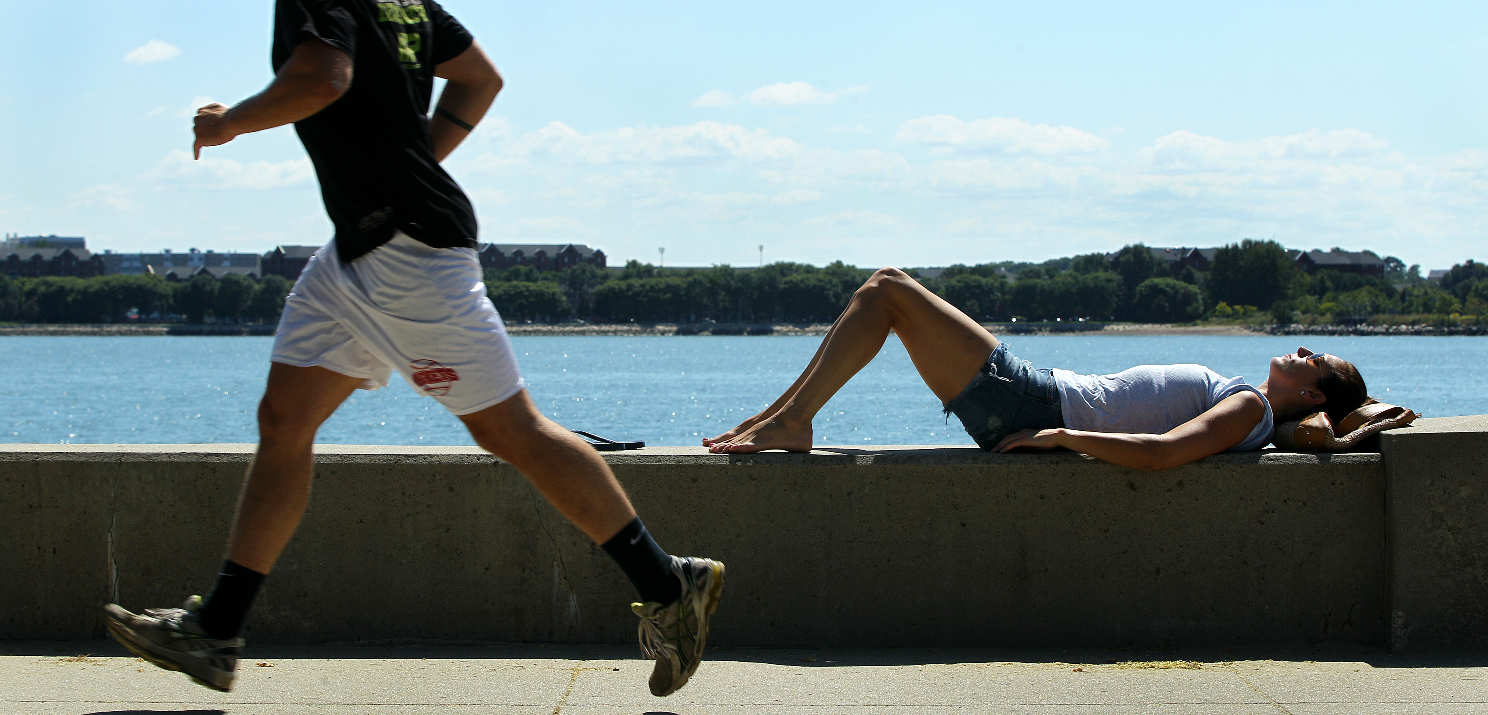 Boston resident Caitlin Jarvis sunbathed on Carson Beach on Sunday. She said lower temperatures this August have thwarted her beach plans.