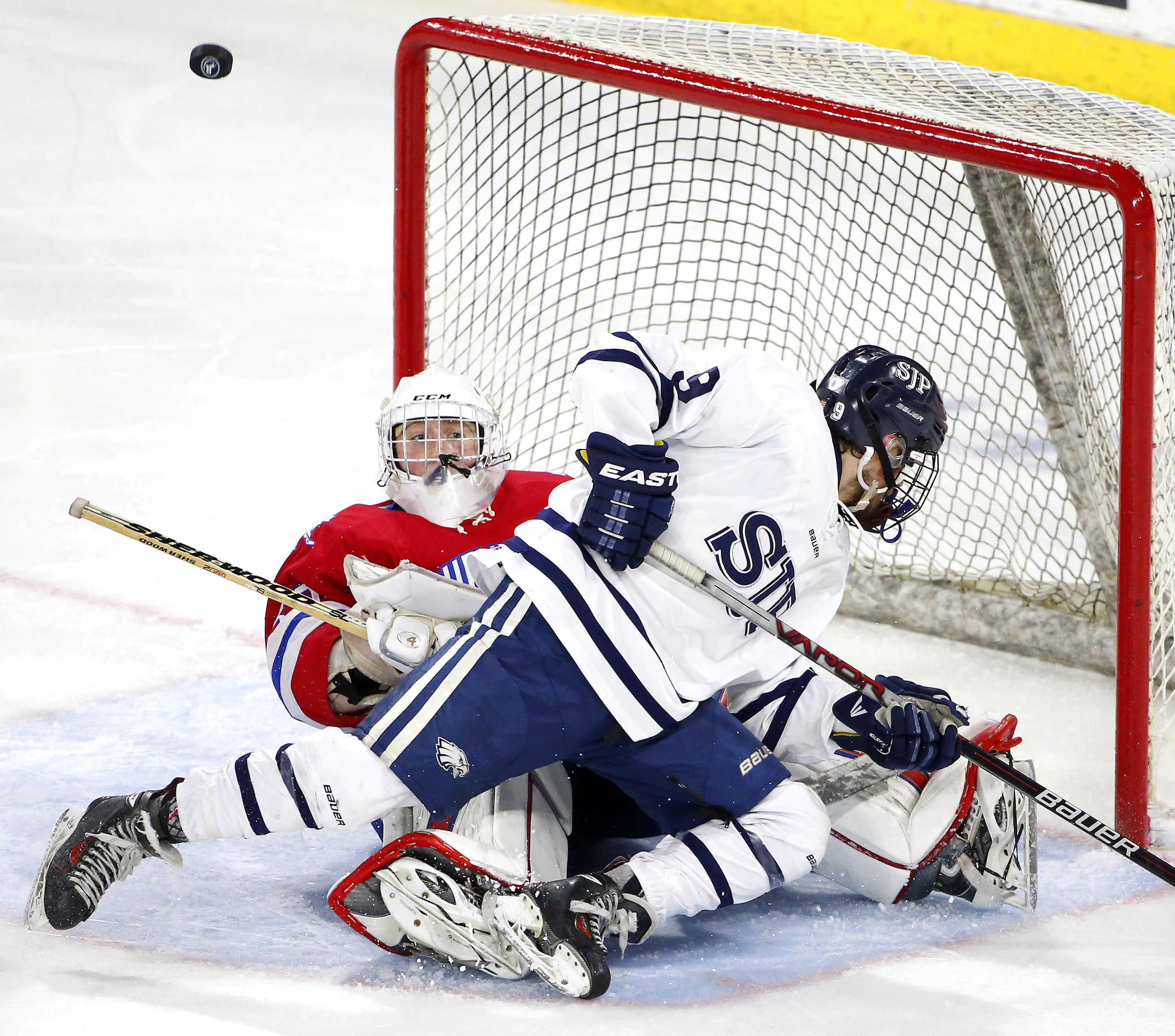 St. John Prep’s Kyle Hentosh crashed into Burlington goalie Nick Howard in search of a rebound.