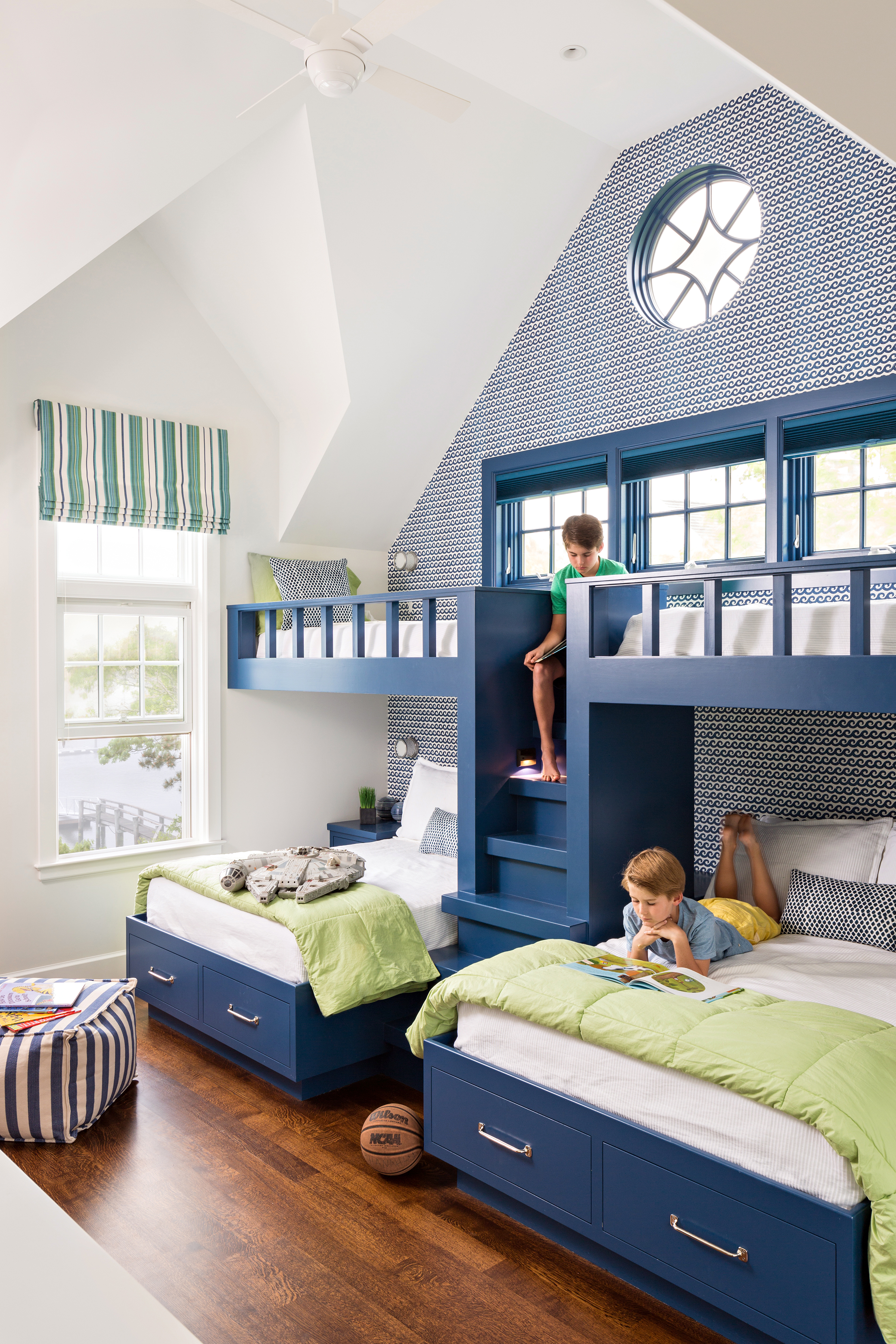 The bunks in the boys’ bedroom are painted Benjamin Moore Downpour Blue to match the wave motif wallpaper, Thibaut’s Shore Thing in navy.