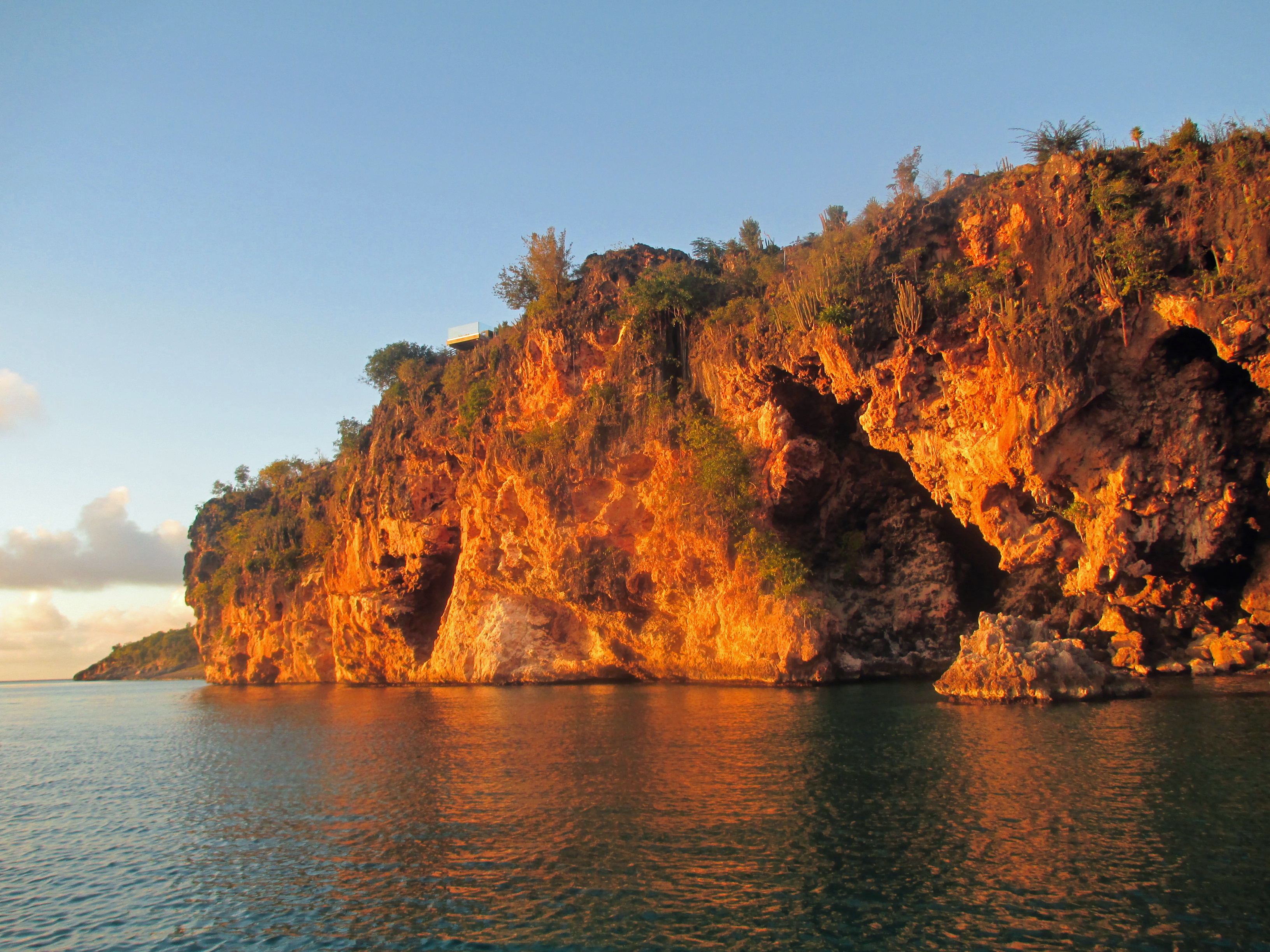 Sunset warms the limestone along the coast of Anguilla seen on a boat ride to Little Bay.