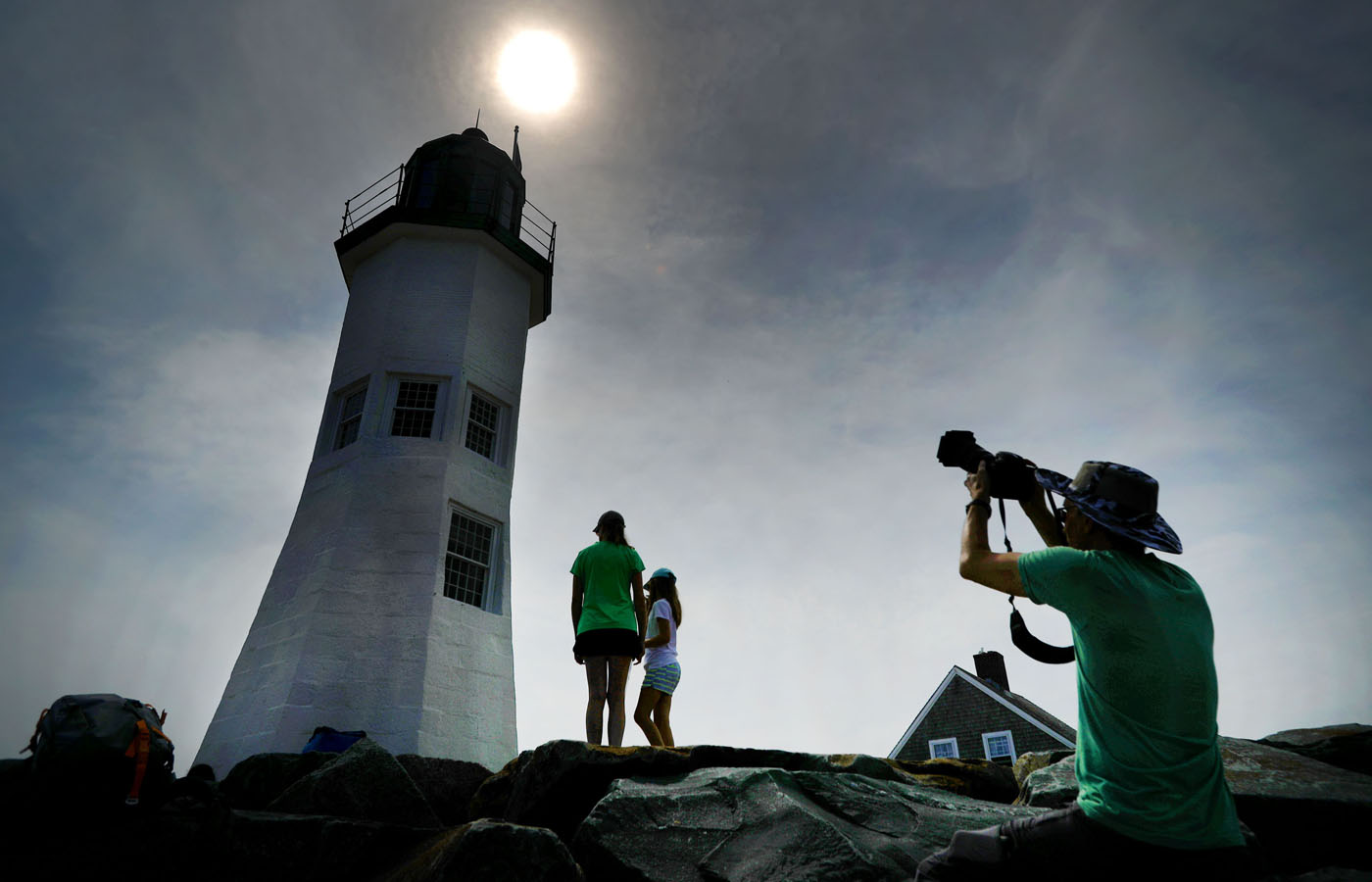 People gathered on the breakwater at the Old Scituate Lighthouse to view the eclipse.