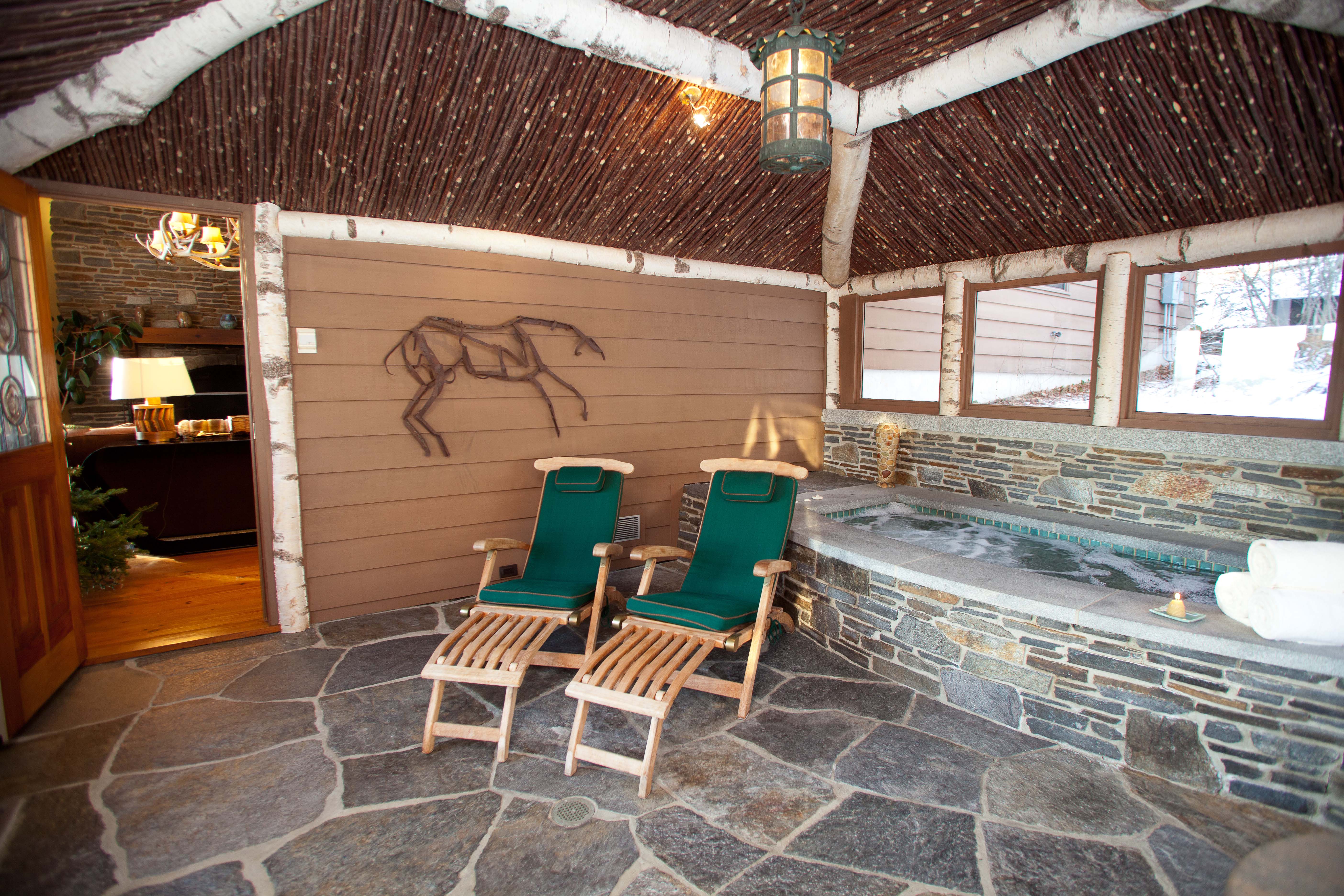 In Log Cabin (above) at Twin Farms, there’s a river rock fireplace and intricate twig work. There’s a hot tub on the porch at Twin Farms’ Chalet.