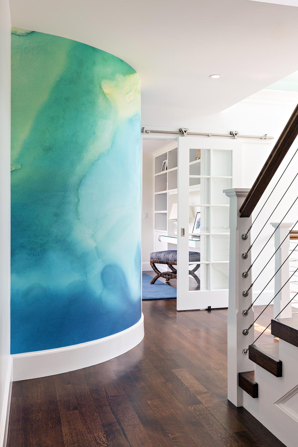A watercolor mural is a surprise statement on the second-floor landing.