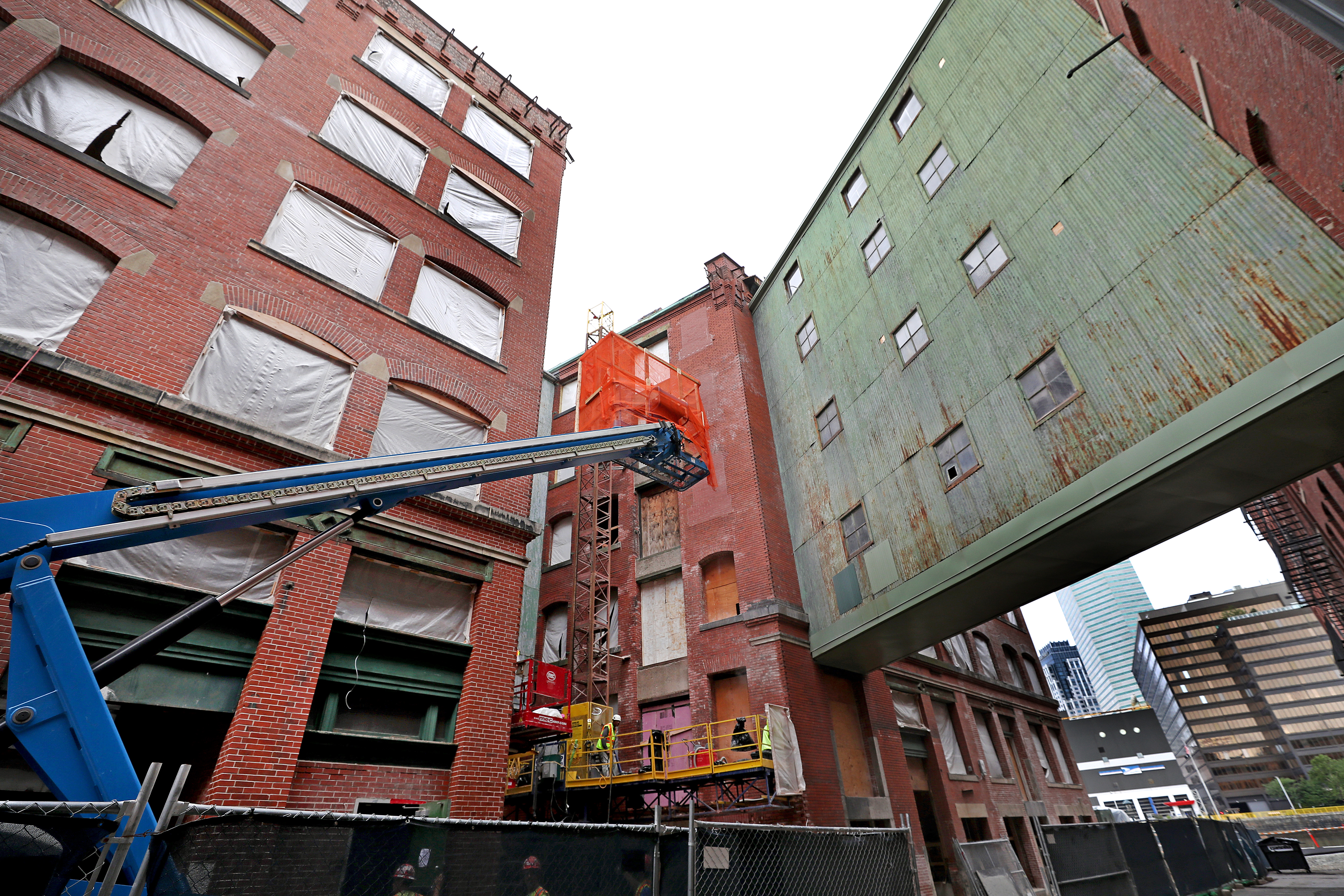 Crews worked on one building’s exterior brickwork as the footbridge (in green) loomed in the background.