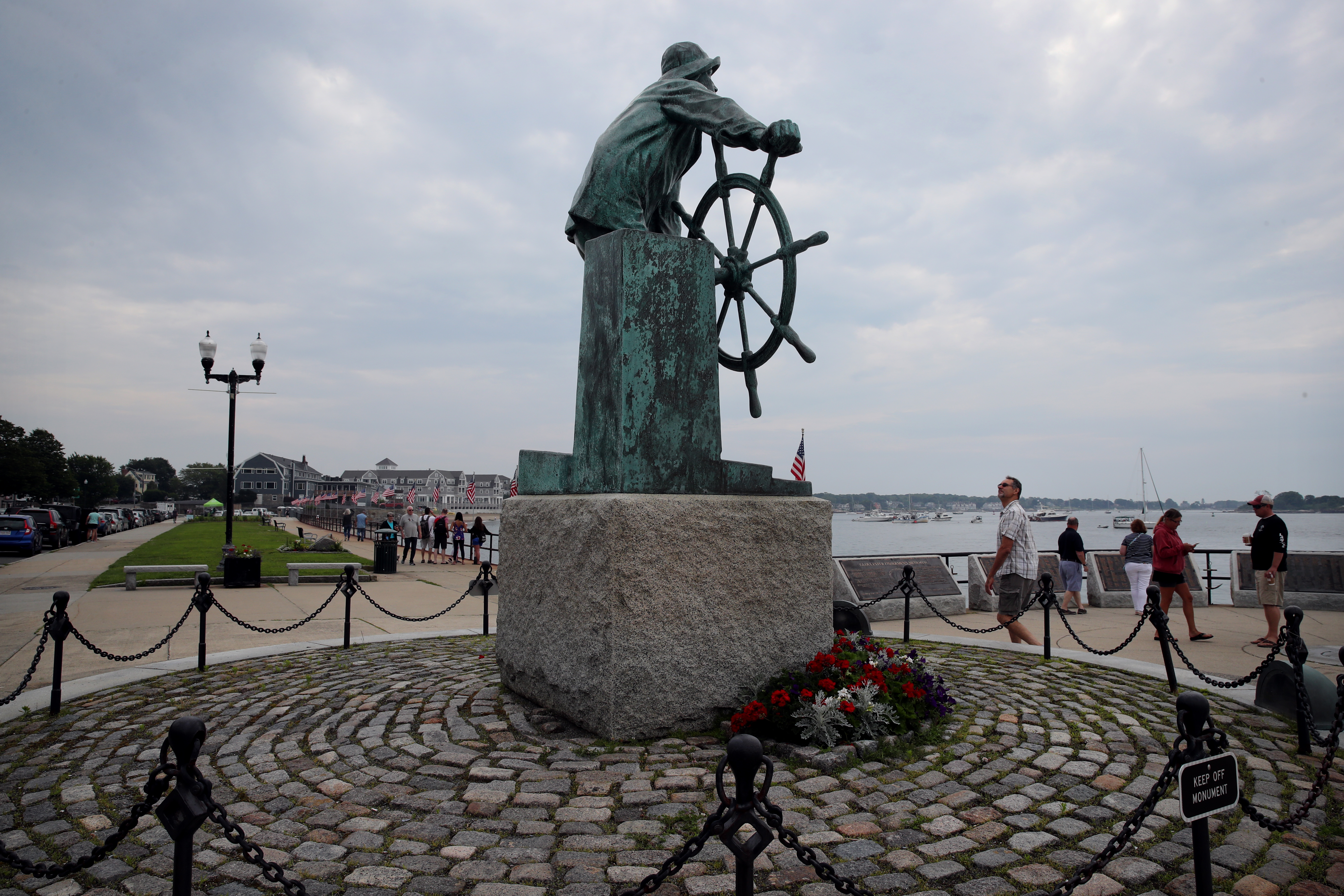 Visitors view the Gloucester Fishermen's Memorial on the Gloucester HarborWalk.