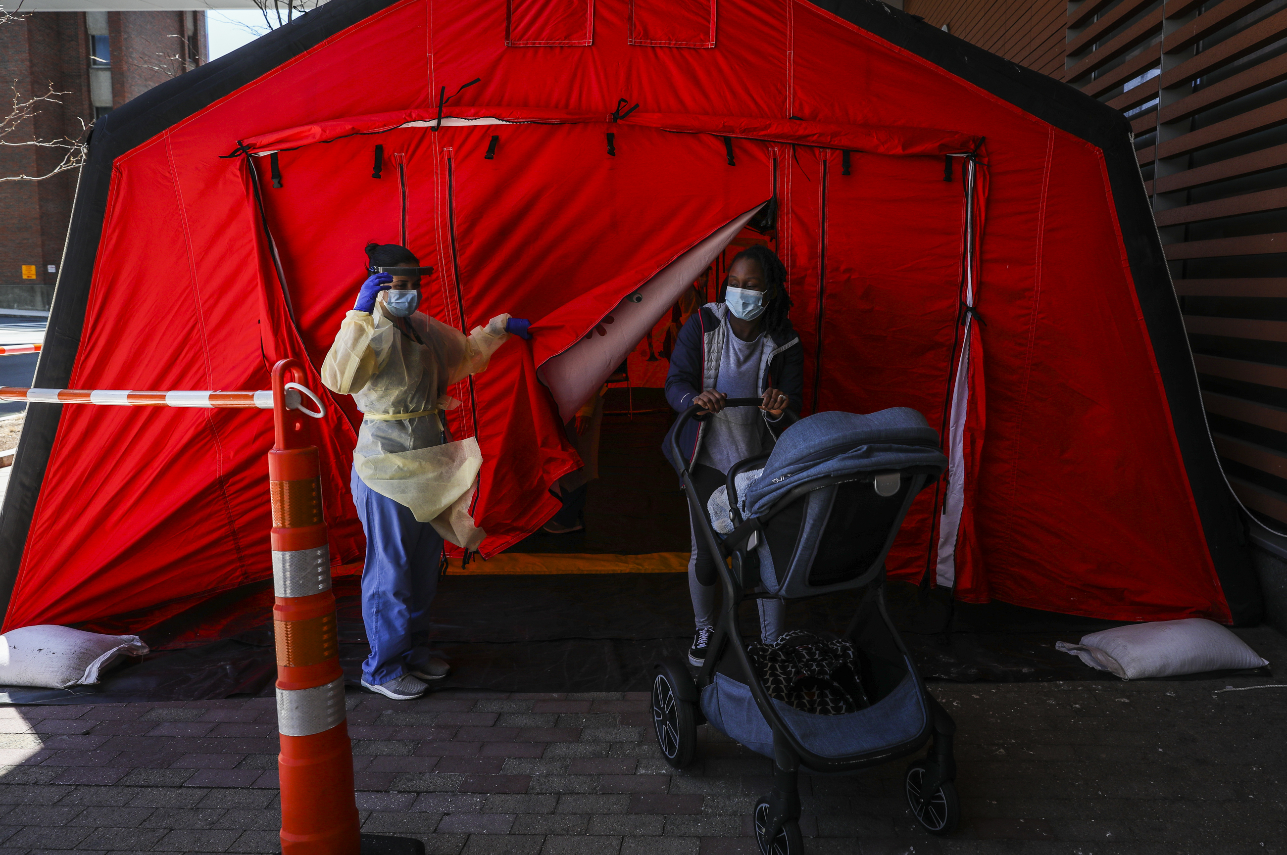 Boston Medical Center nurse Mary Angelides (left) waved goodbye to Louxandra Clark and 14-month-old Eljay Clark after they received routine vaccinations in a pediatrics tent set up outside of Boston Medical Center.