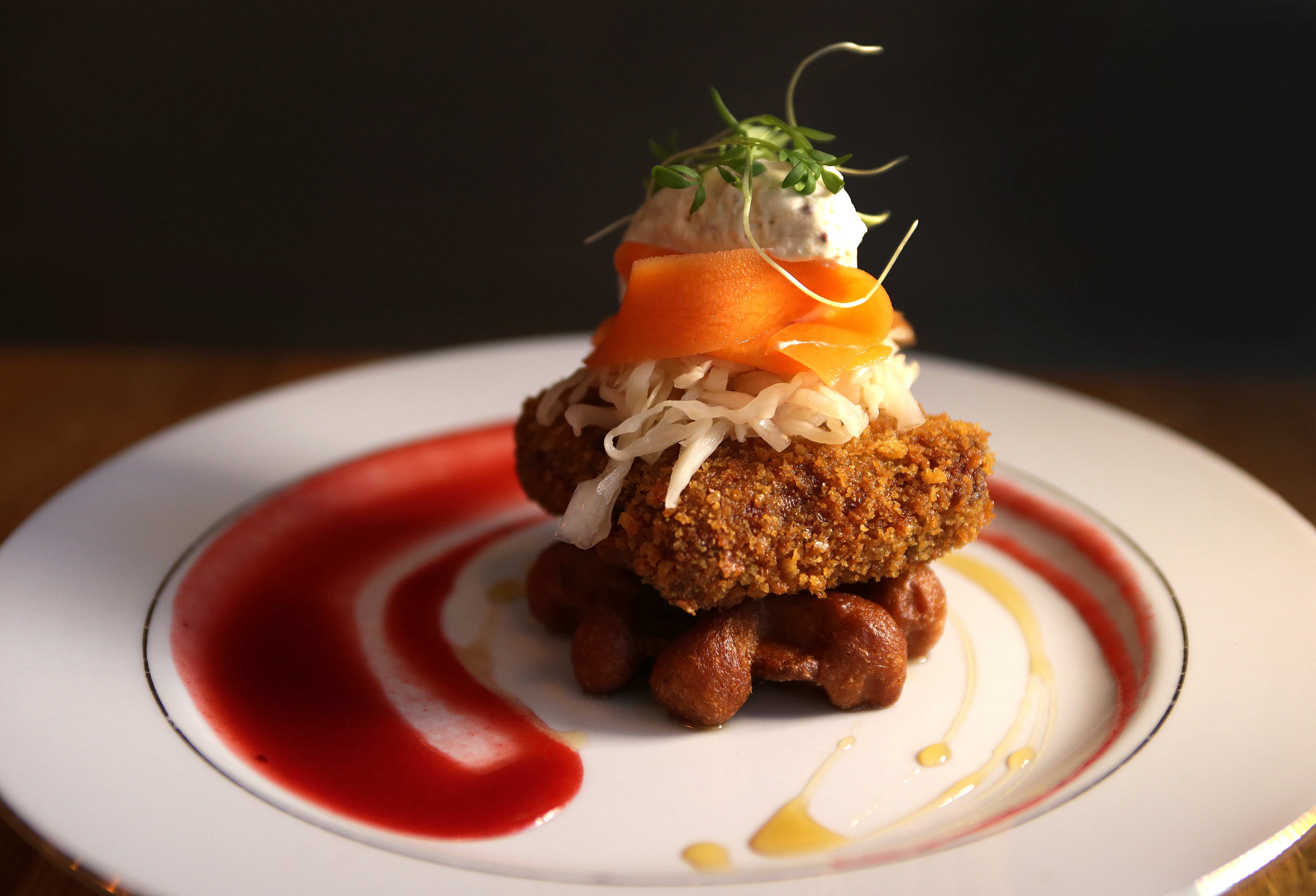 Trotters and waffles feature pig’s feet breaded and fried, served on a brioche waffle with Dijon-maple whip, pickled carrots, and spicy cranberry sauce.