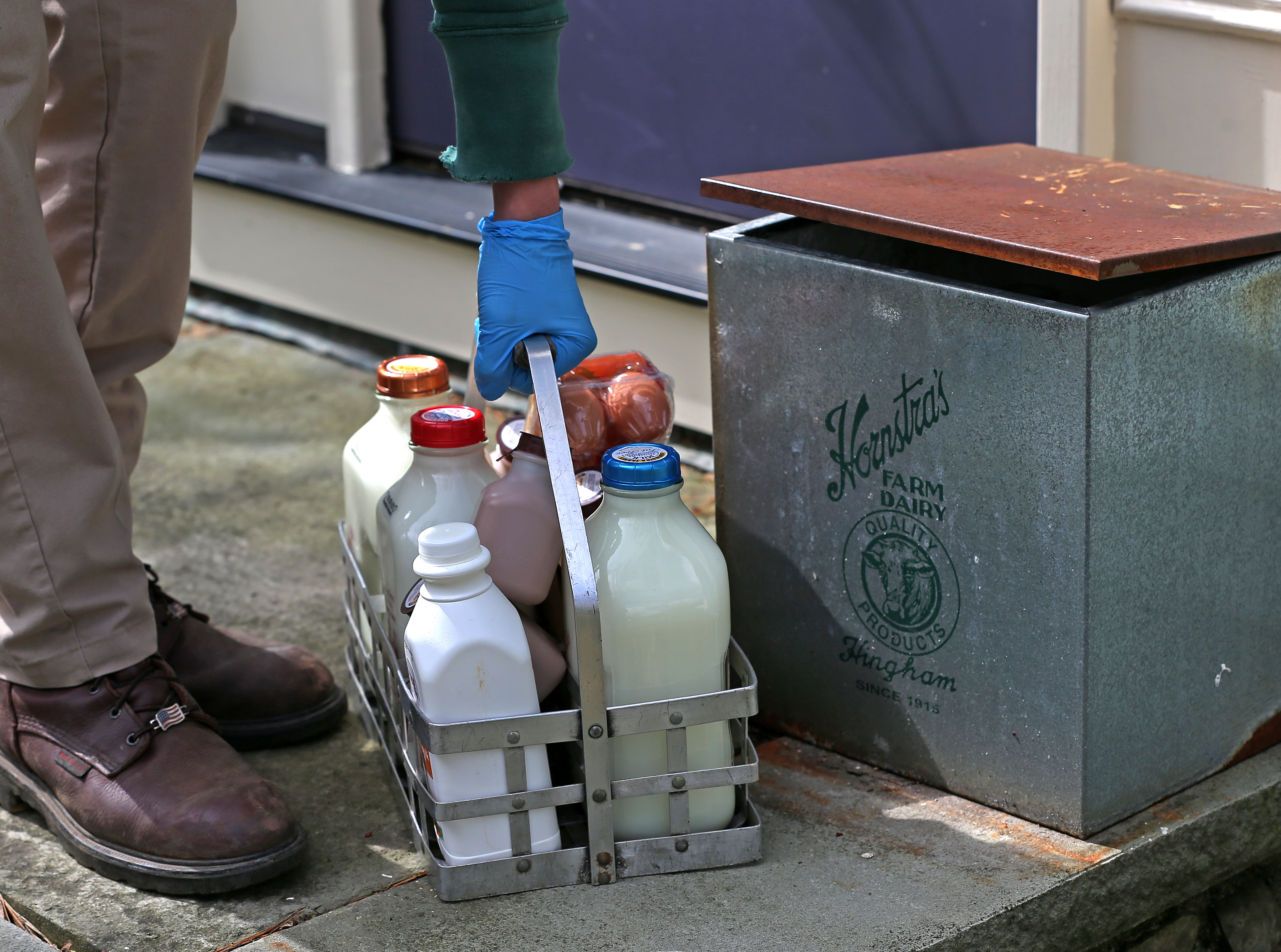 John Hornstra of Hornstra Farms set milk bottles down outside a house in Norwell.